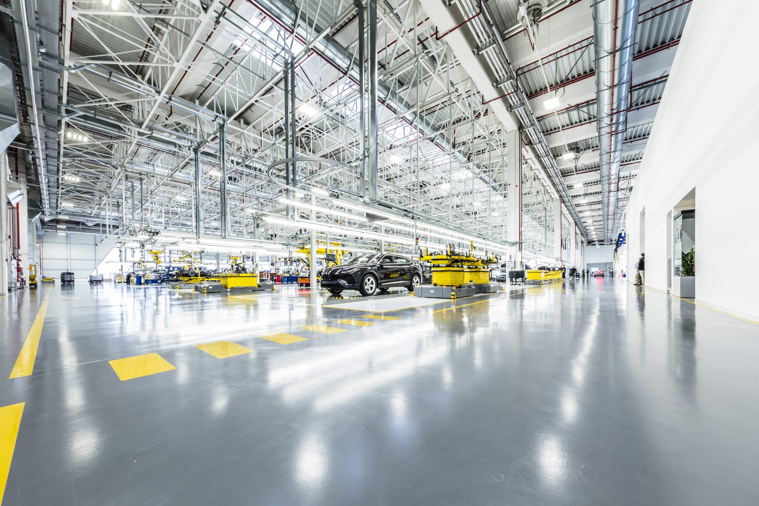 How Lamborghini'S Chief Procurement Officer Kept The Factory Running Through Pandemic, Chip Shortage, And War 11 Wide shot of the modern lamborghini factory floor with a grey urus suv on the assembly line surrounded by advanced machinery