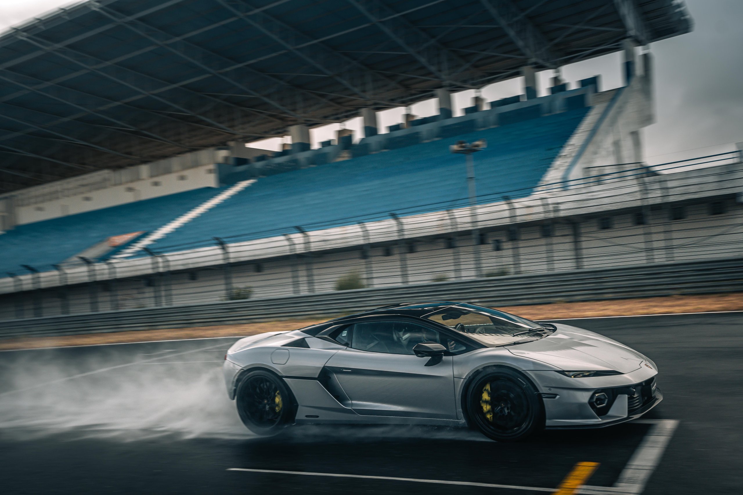 Fifteen Days At Estoril: What Lamborghini'S Temerario Launch Reveals About Its Hybrid Ambitions 7 Silver lamborghini temerario drifting on the estoril racetrack creating tire smoke with grandstands in the background