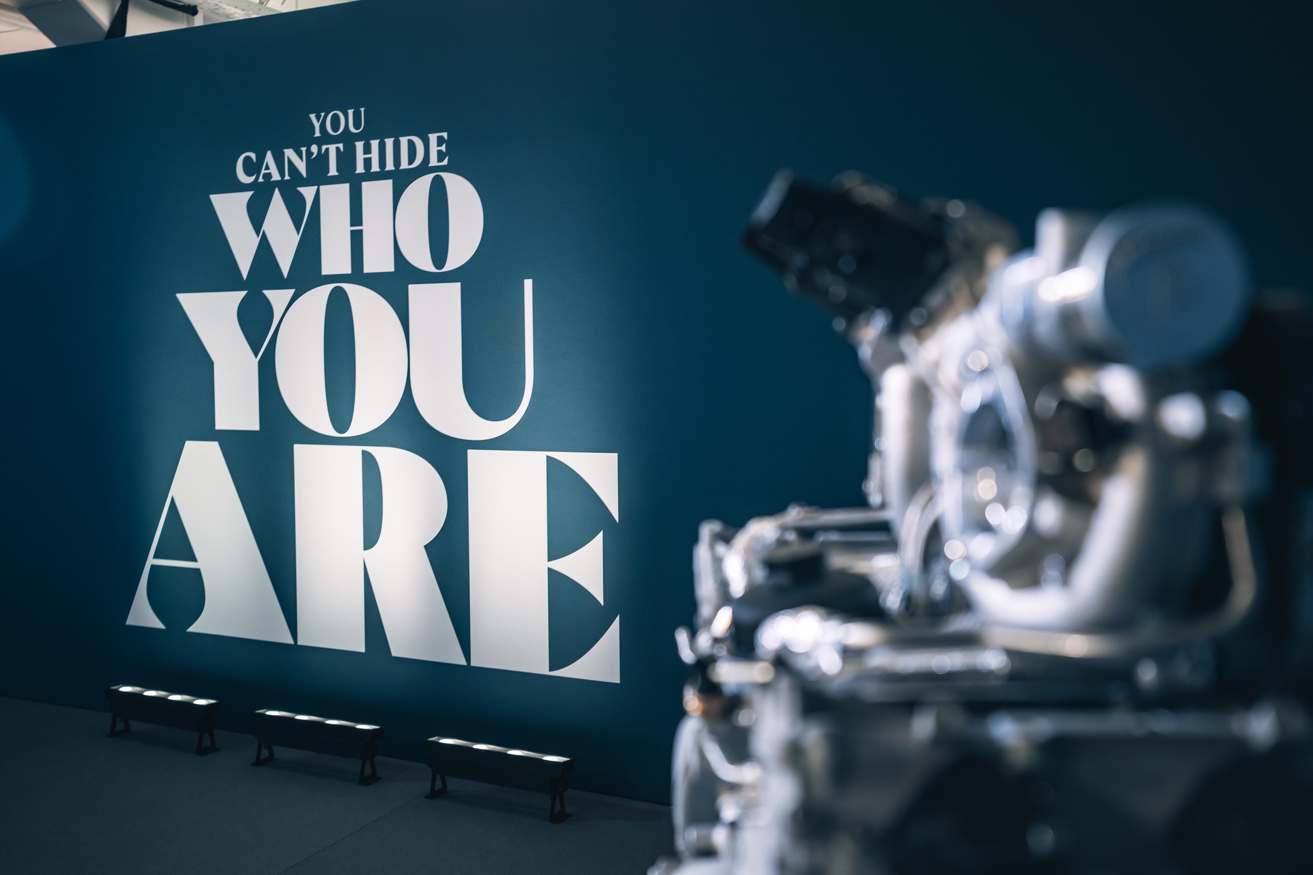 Fifteen Days At Estoril: What Lamborghini'S Temerario Launch Reveals About Its Hybrid Ambitions 5 Wall displaying 'you can't hide who you are' text with a blurred engine in the foreground at the temerario launch