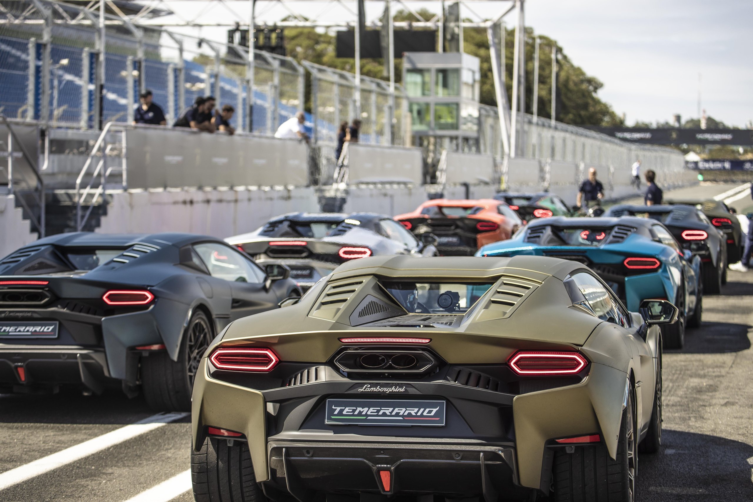 Fifteen Days At Estoril: What Lamborghini'S Temerario Launch Reveals About Its Hybrid Ambitions 11 Line of lamborghini temerario supercars in various colors parked on the estoril pit lane with spectators in the background