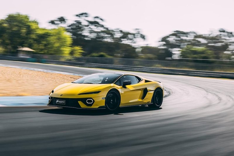 Yellow Lamborghini Temerario speeding through a corner at the Estoril circuit with motion blur