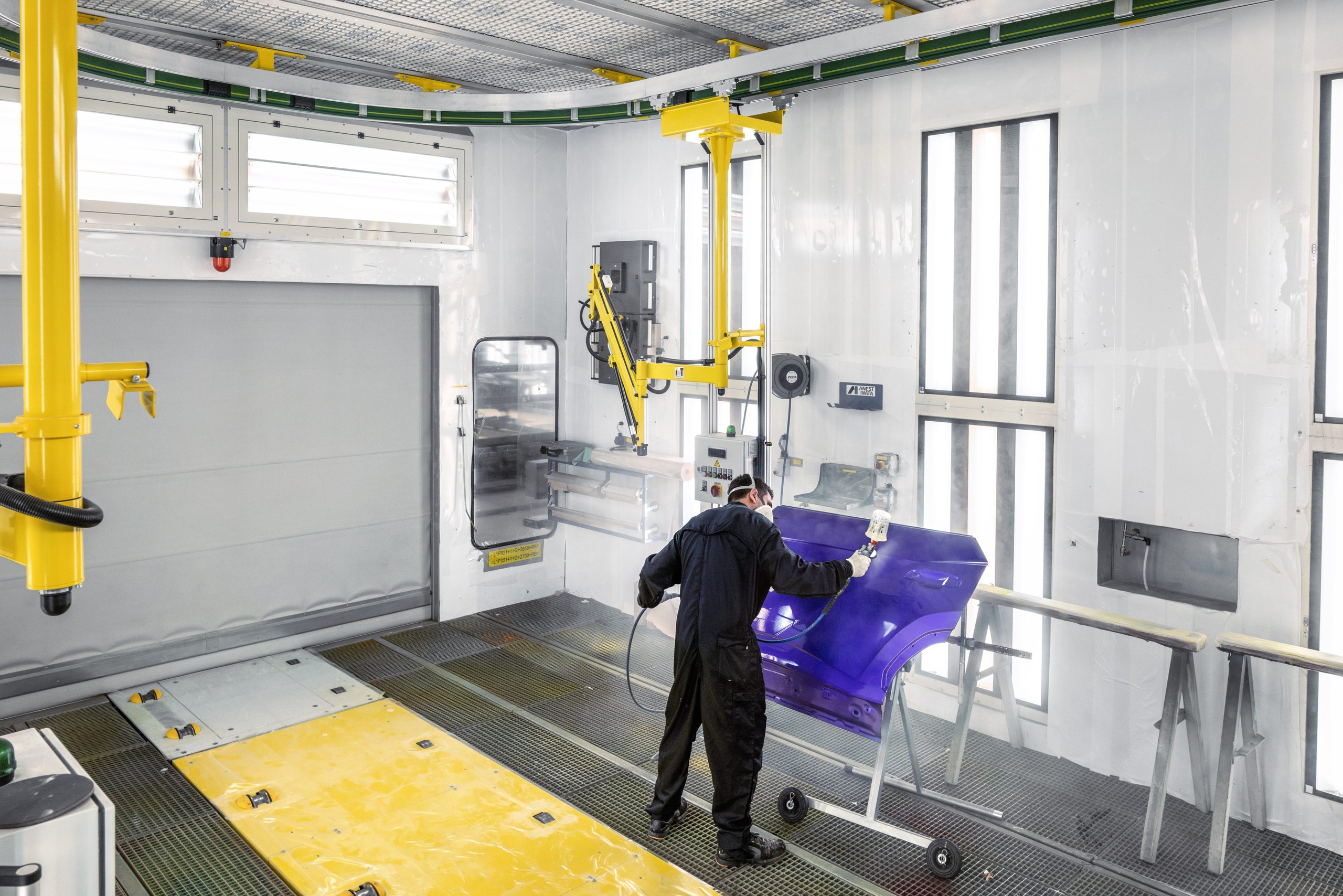 Italy'S Most Desirable Automotive Employer Builds Lamborghinis, And That Matters More Than You Think 7 Lamborghini paint specialist in protective suit spraying a vibrant purple panel in the factory paint booth