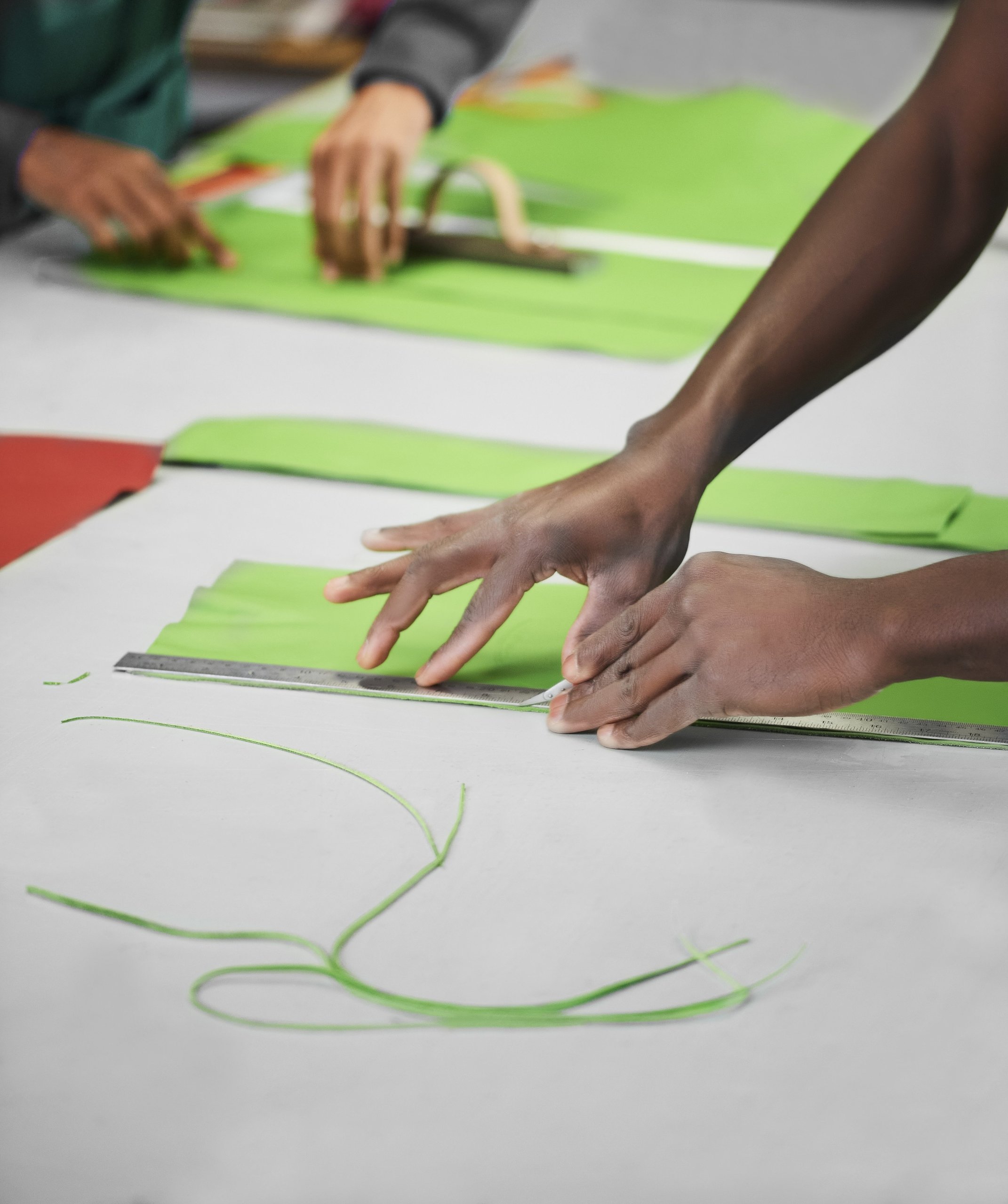 Lamborghini'S Upcycled Leather Project Turns Supercar Factory Scraps Into Covetable Accessories 7 Artisan hands precisely cutting green leather with a ruler and craft knife at cartiera workshop