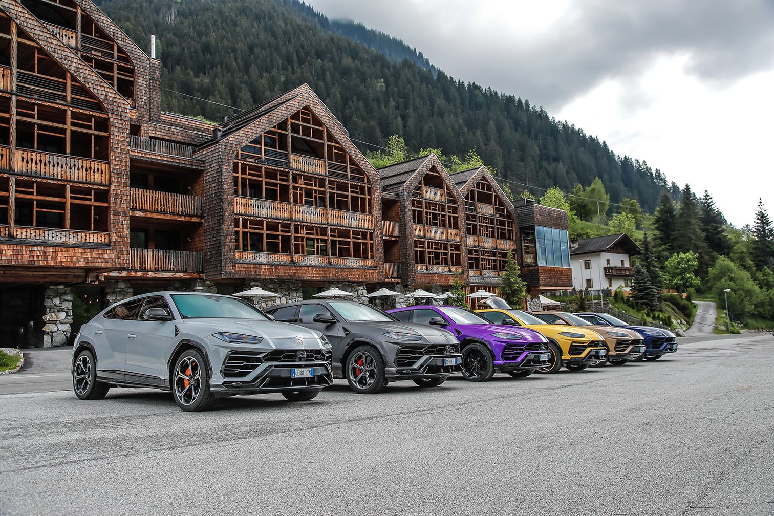 20,000 Urus Units In Four Years: How Lamborghini'S Bestseller Doubled The Entire Company 9 A line of colorful lamborghini urus suvs parked at a mountain resort showcasing ad personam color variety