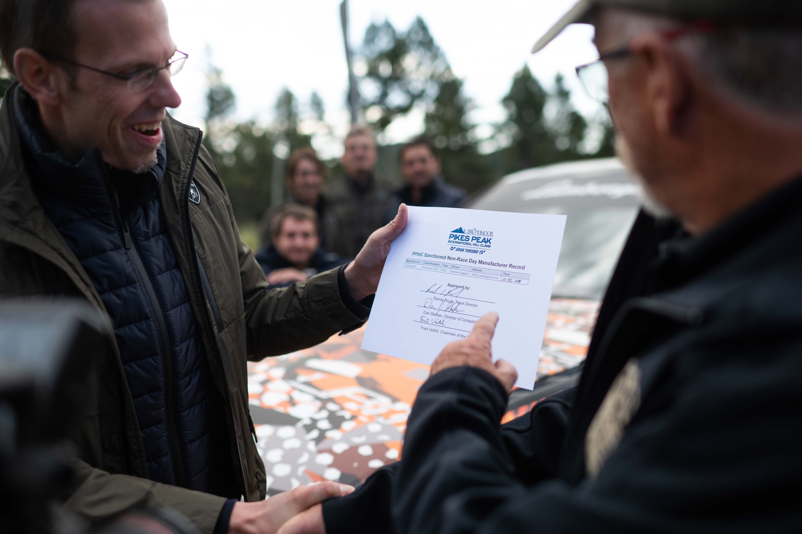 A Camouflaged Urus Just Demolished The Pikes Peak Suv Record By 17 Seconds 11 Two men shaking hands while presenting the official pikes peak international hill climb record certificate with the lamborghini urus in the background