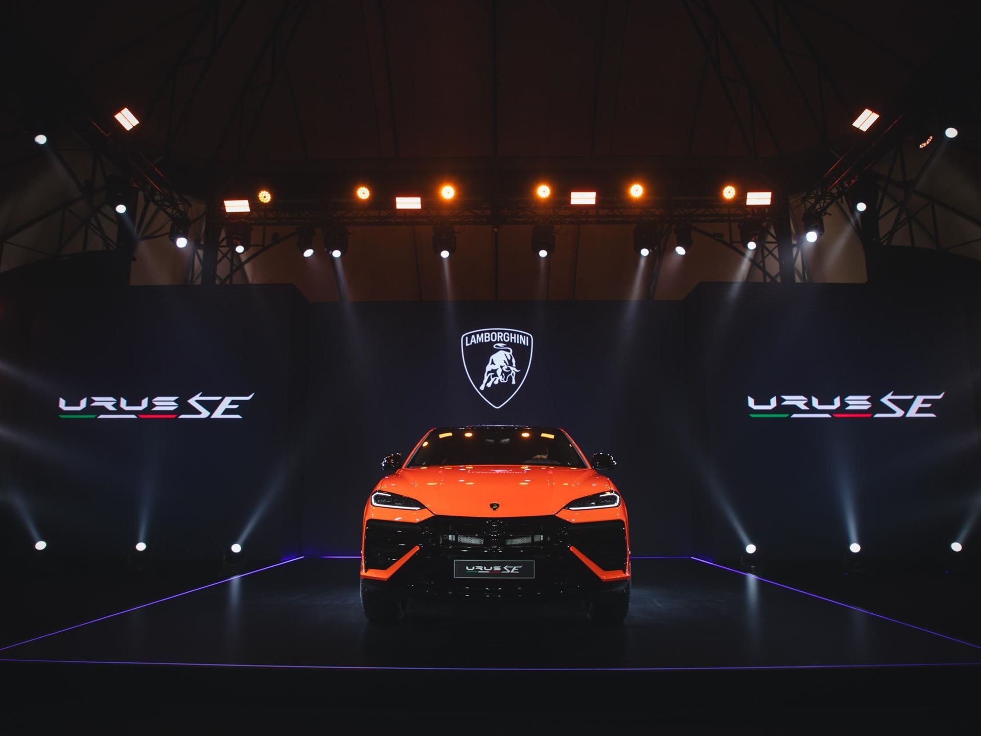 Lamborghini Brings The 800 Cv Urus Se To Bangkok, Pairing Plug-In Hybrid Power With Southeast Asian Ambition 3 Orange lamborghini urus se on stage at the bangkok launch event with lamborghini branding and urus se text on screens