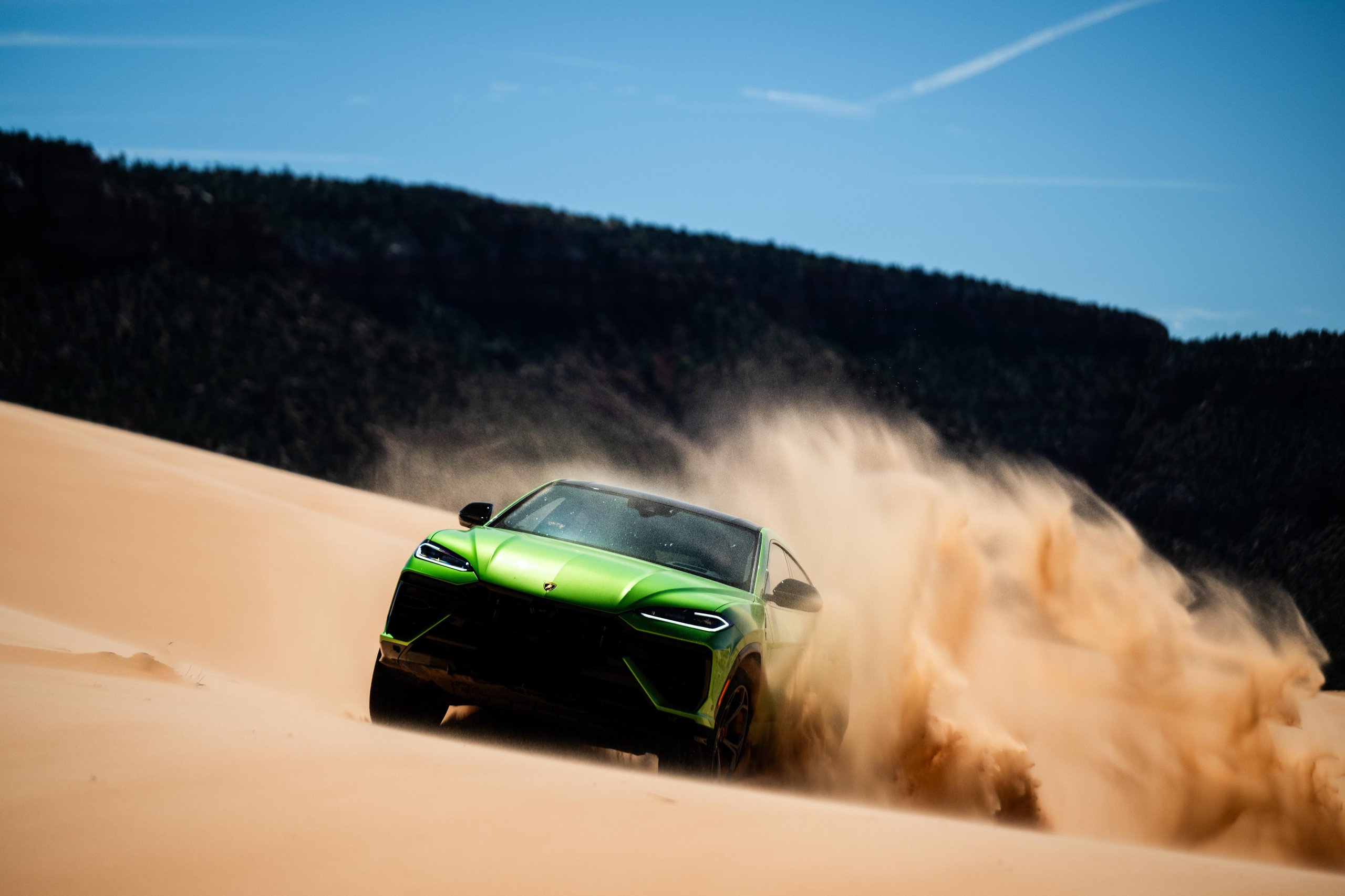 Lamborghini Sent A Convoy Of Urus Ses Into Zion'S Desert. The Real Destination Was Brand Loyalty. 7 Green lamborghini urus se driving through sand dunes kicking up a large plume of sand