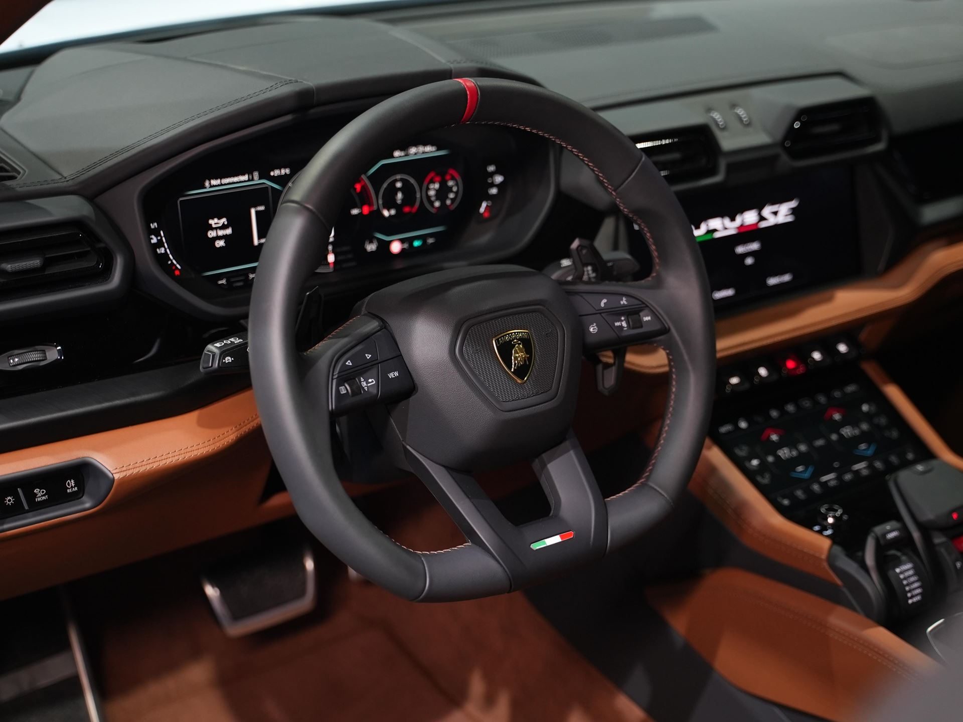 Lamborghini Urus Se Lands In India: 800 Cv, A Plug-In Hybrid Powertrain, And A New Chapter For The Super Suv 5 Lamborghini urus se interior showing the flat-bottom steering wheel with lamborghini emblem, digital dashboard, and brown leather trim