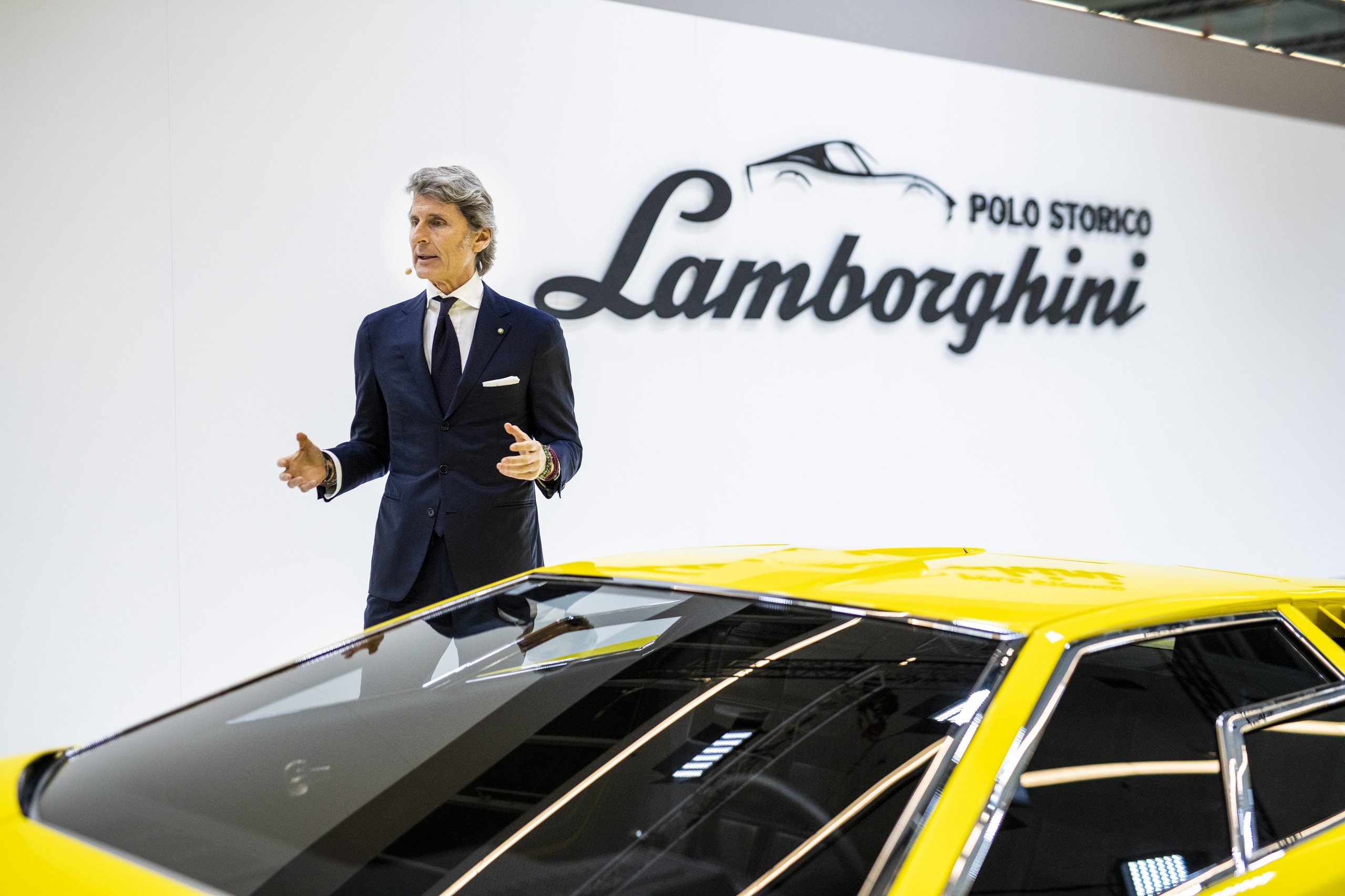 25,000 Hours To Build A Bridge: How Polo Storico'S Resurrected Countach Lp 500 Frames Lamborghini'S Hybrid V12 Future 9 Stephan winkelmann speaking on stage beside the countach lp 500 prototype at rétromobile