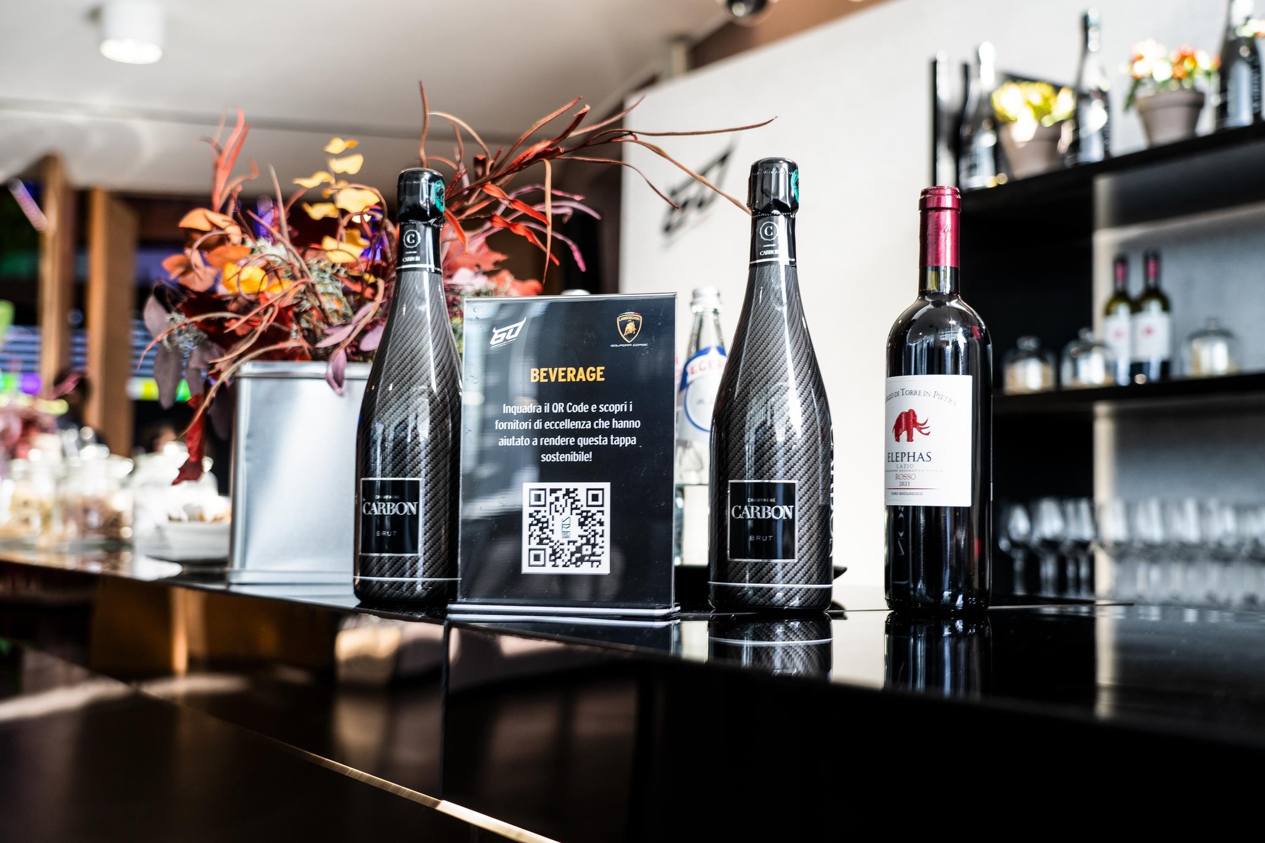 Lamborghini'S World Finals Earned A Sustainability Certification Most Motorsport Events Don'T Bother Pursuing 5 Bar counter at the lamborghini world finals featuring sustainable beverages and a qr code sign for sustainability information