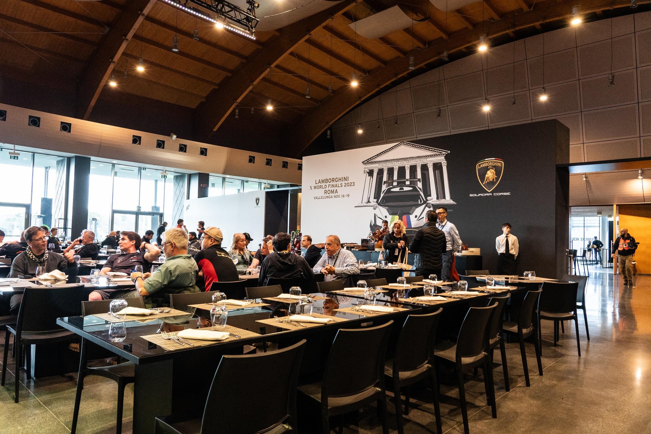 Lamborghini'S World Finals Earned A Sustainability Certification Most Motorsport Events Don'T Bother Pursuing 11 Indoor event space at the lamborghini world finals 2023 with attendees and a screen displaying the event branding