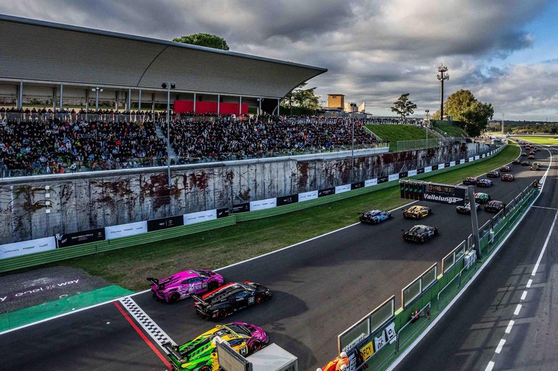 Aerial view of Lamborghini Huracán Super Trofeo EVO2 race cars approaching the start line at Vallelunga with packed grandstands