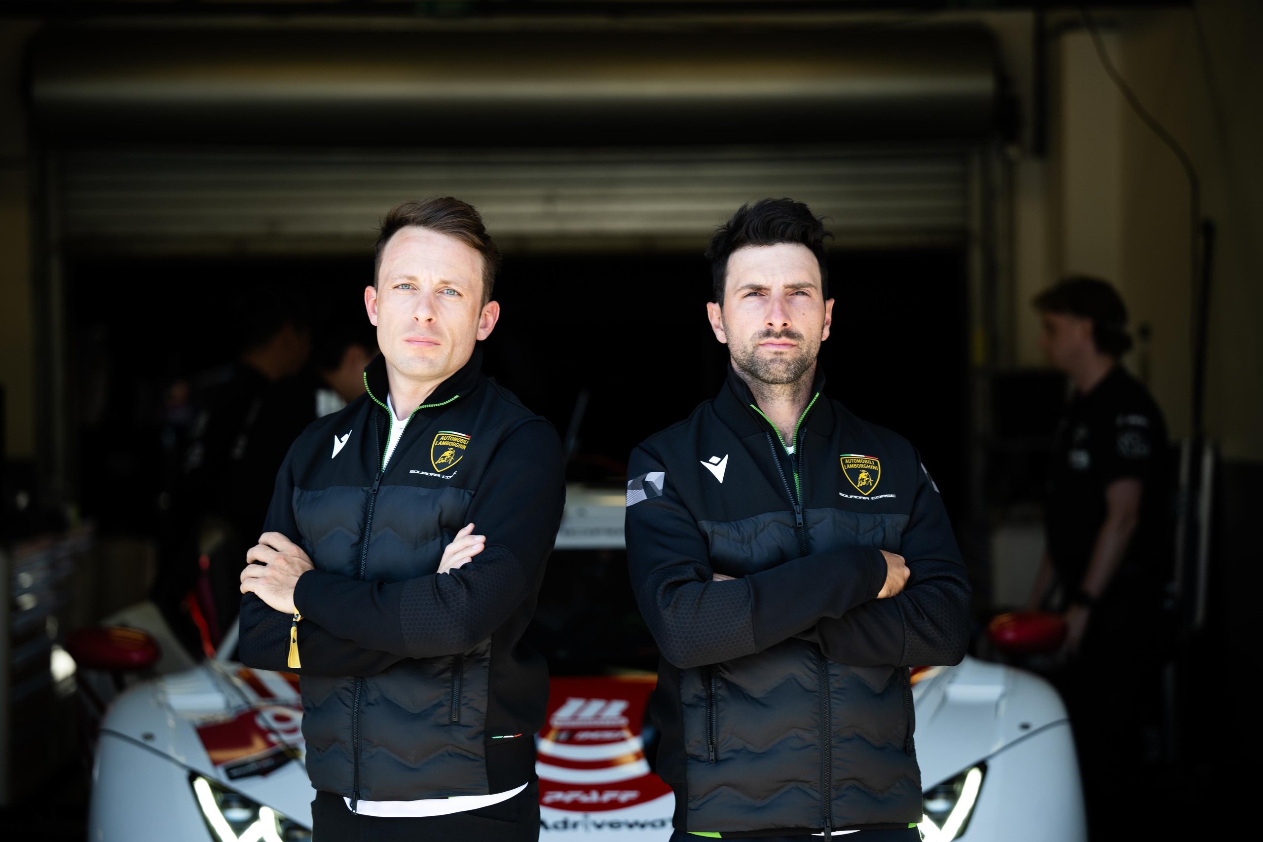 Squadra Corse Rewrites Its Talent Playbook: 26 Drivers Enter Lamborghini'S Merit-Based Pipeline For 2025 9 Two lamborghini squadra corse team members standing in front of a white huracán gt3 evo2 in a pit garage