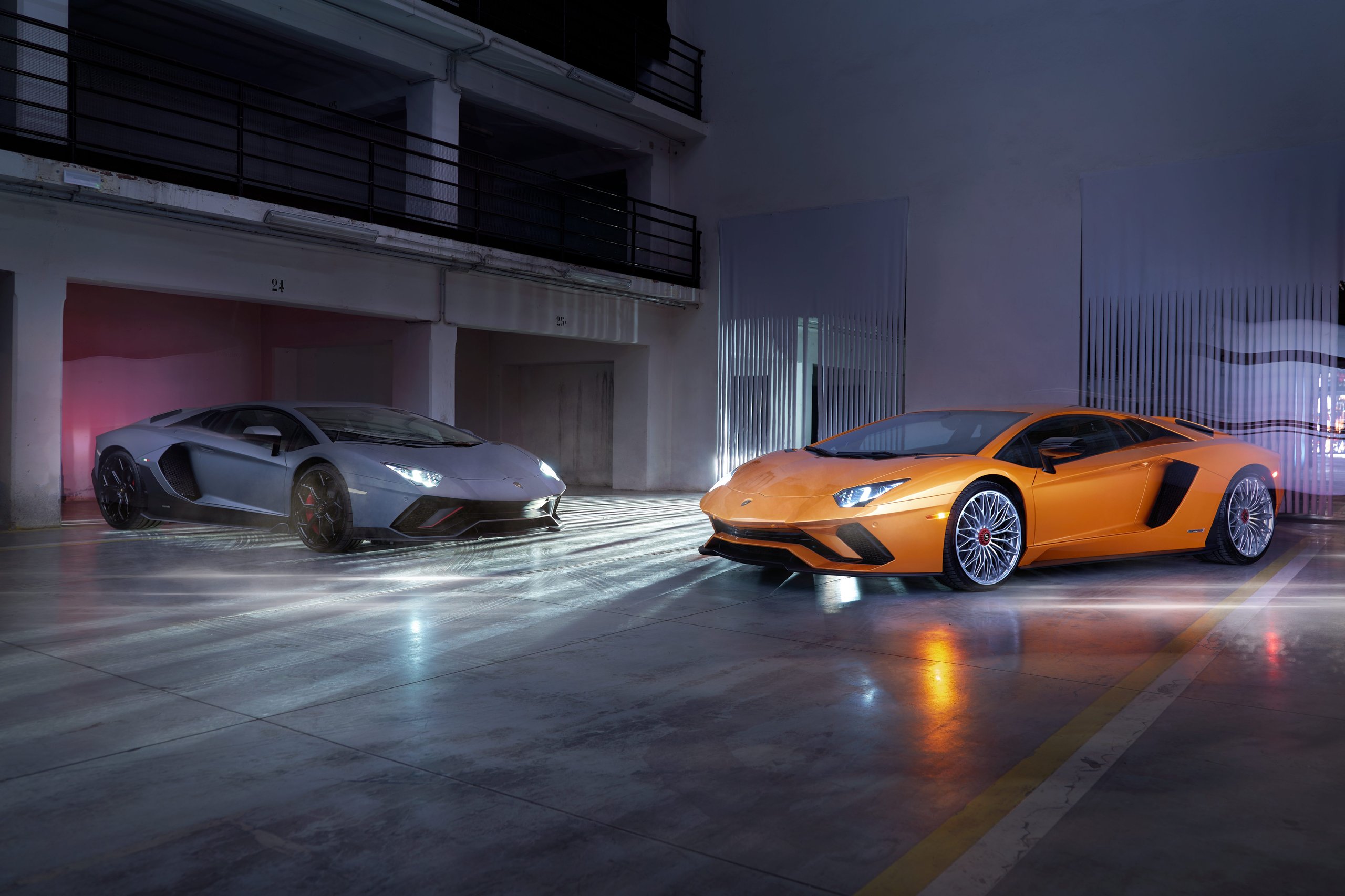 The Last Pure V12 Lamborghini Rolled Off The Line In Light Blue, And Nothing Will Replace What It Represented 9 Grey aventador svj and orange aventador ultimae parked side by side in an underground garage