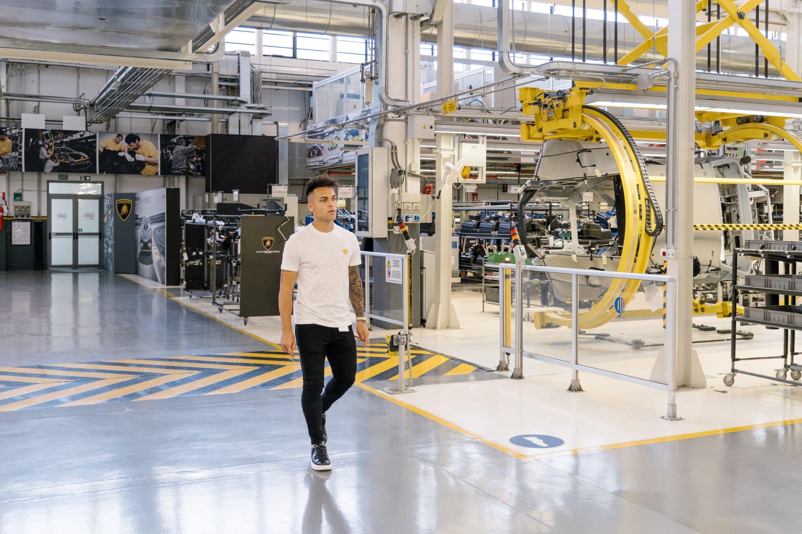 Inside Lautaro Martinez'S Bespoke Urus Configuration At Lamborghini'S Sant'Agata Factory 11 Lautaro martinez walking through the brightly lit lamborghini factory floor with machinery and assembly stations in the background