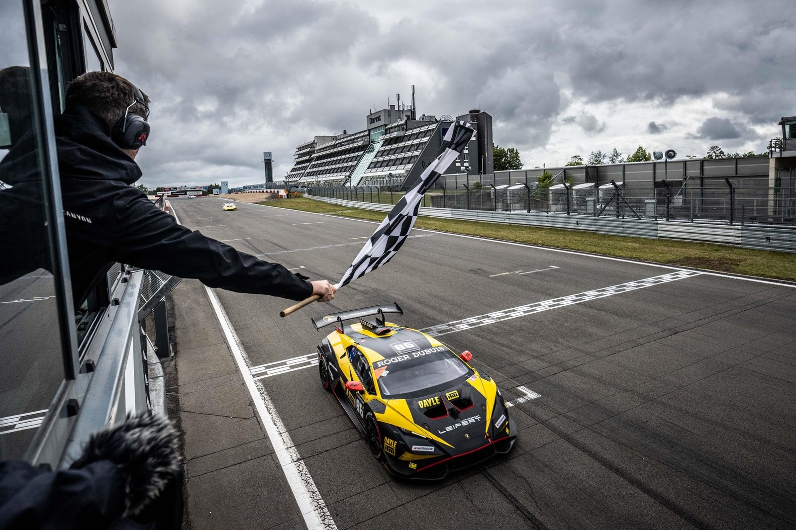 Lamborghini Huracán Super Trofeo EVO2 crossing the finish line at Nürburgring with checkered flag waving