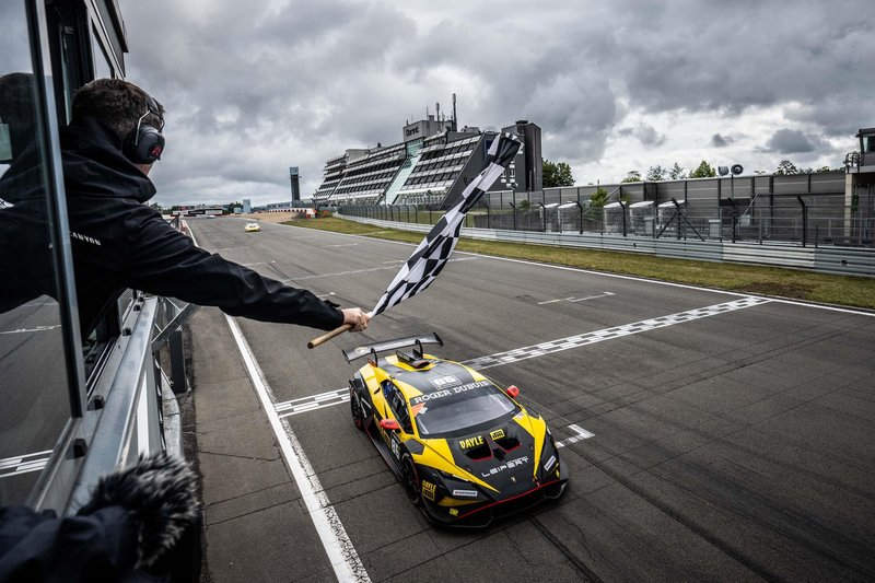 Lamborghini Huracán Super Trofeo EVO2 crossing the finish line at Nürburgring with checkered flag waving