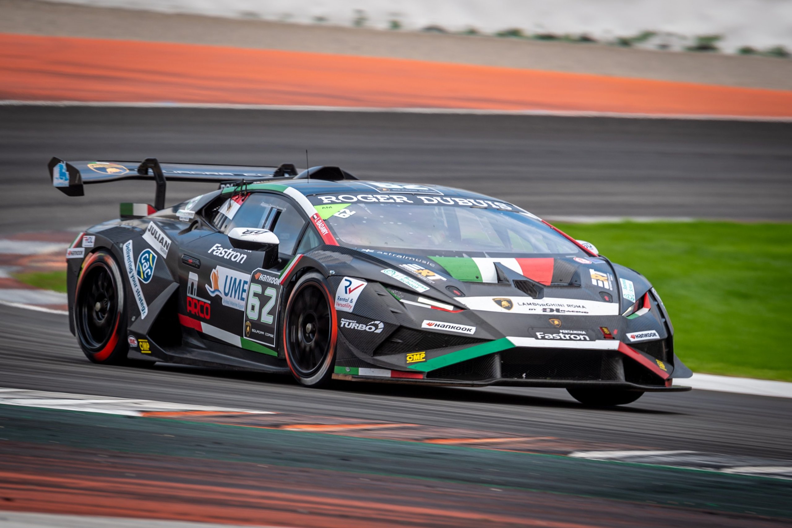 A black lamborghini huracán super trofeo evo2 with italian flag livery attacks a corner on the valencia circuit