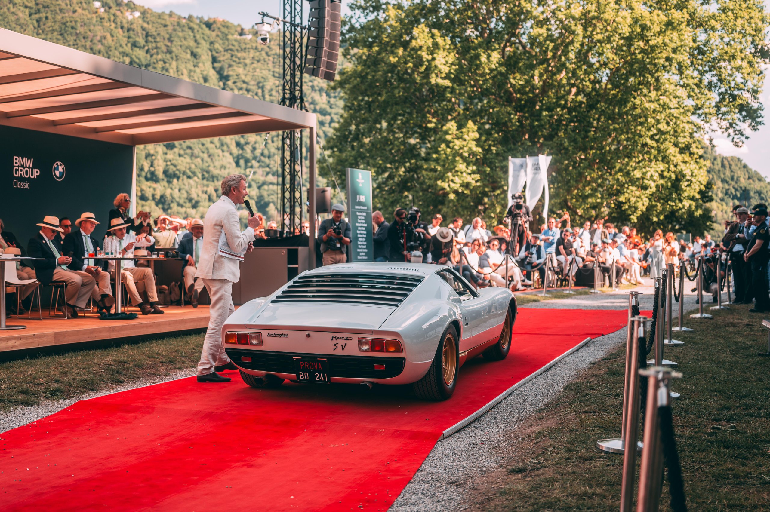 A 1971 Miura Sv Just Won At Villa D'Este, And Its 60Th Anniversary Timing Could Not Be Better 9 White lamborghini miura sv presented on red carpet at villa d'este with a speaker addressing the audience