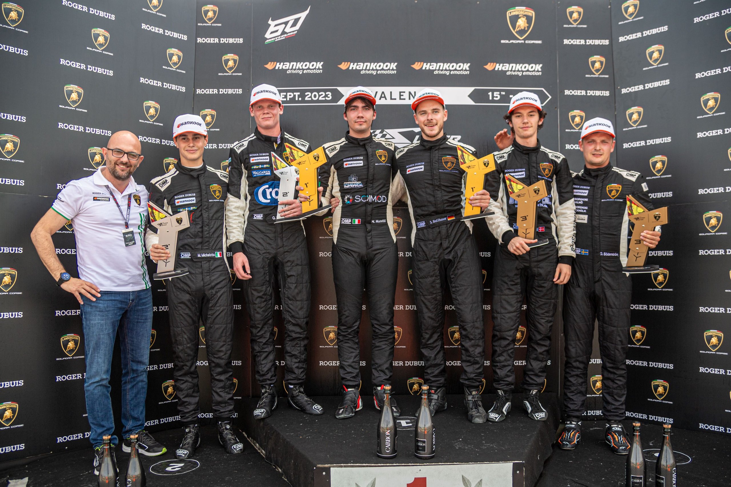 Six individuals on the podium holding trophies at the Lamborghini Super Trofeo Europe Valencia round