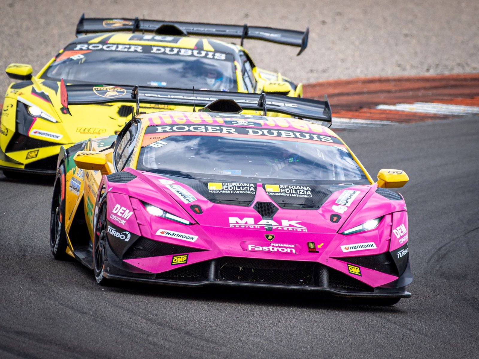 Two Lamborghini Huracán Super Trofeo EVO2 race cars battling wheel-to-wheel on the Valencia circuit
