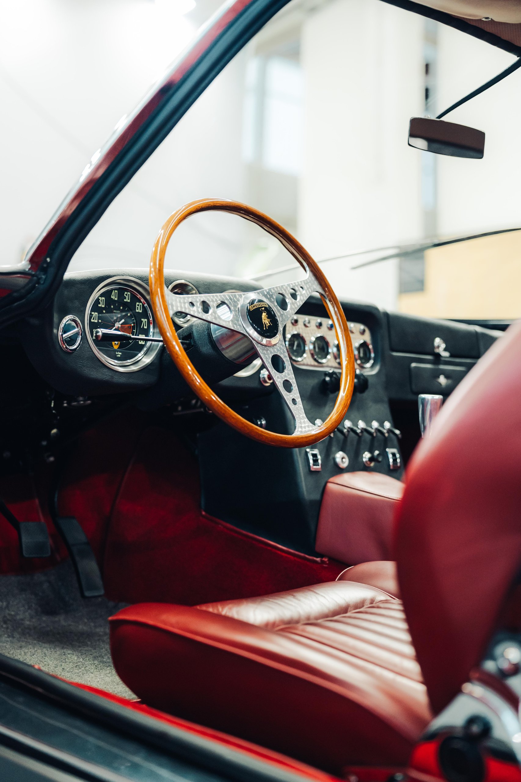 Polo Storico'S Oldest Surviving Lamborghini And A 2026 Miura Tour Signal Where The Brand'S Heritage Strategy Is Heading 5 Close-up of the classic red interior of a lamborghini 350 gt showing wooden steering wheel and vintage dashboard gauges