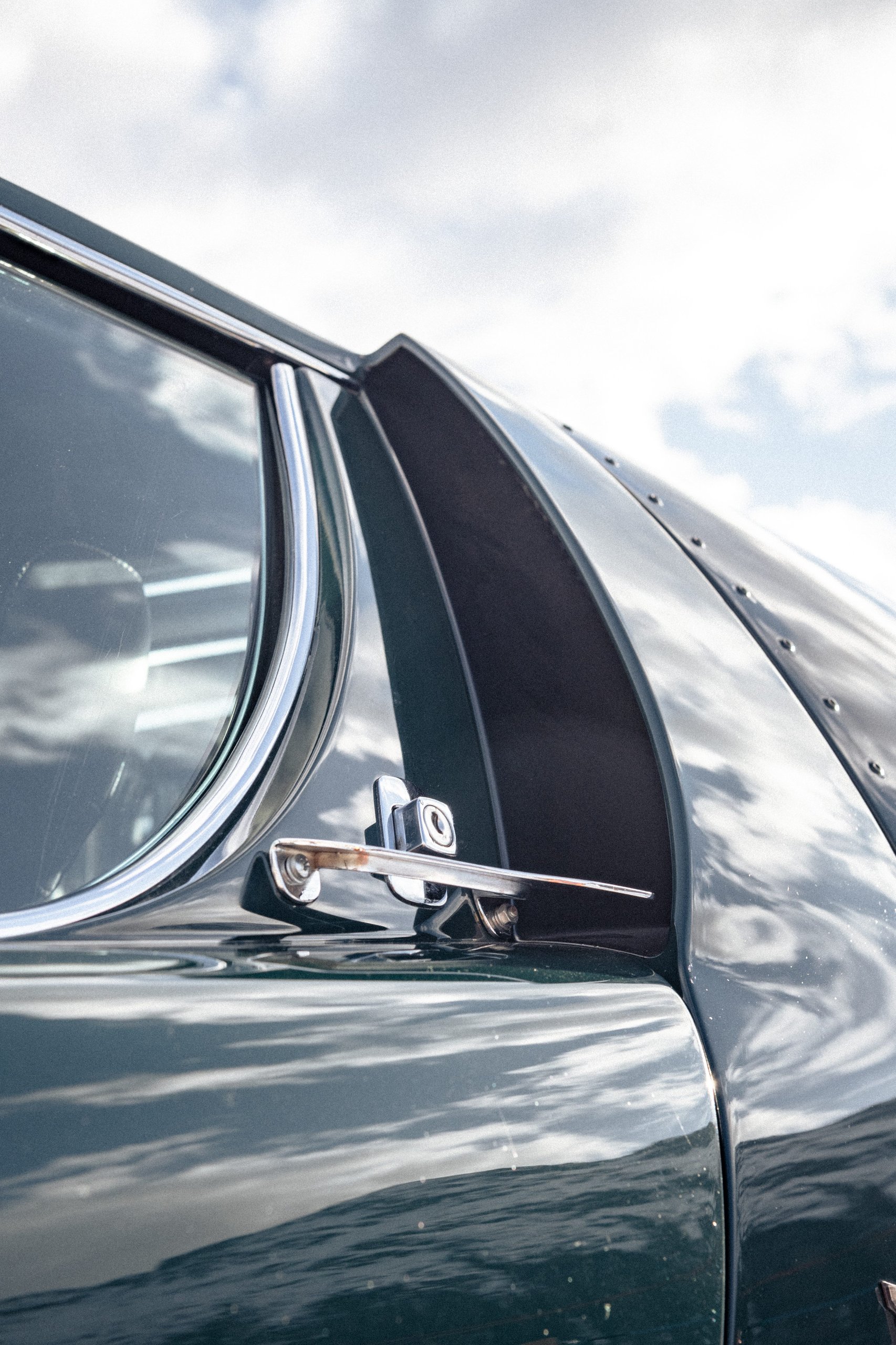 Close-up of the riveted body panels and chrome svr-style vent on the dark green lamborghini miura millechiodi