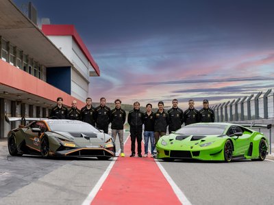 Lamborghini squadra corse young driver program winners standing between two huracán gt3 evo2 race cars at the portimão circuit at sunset