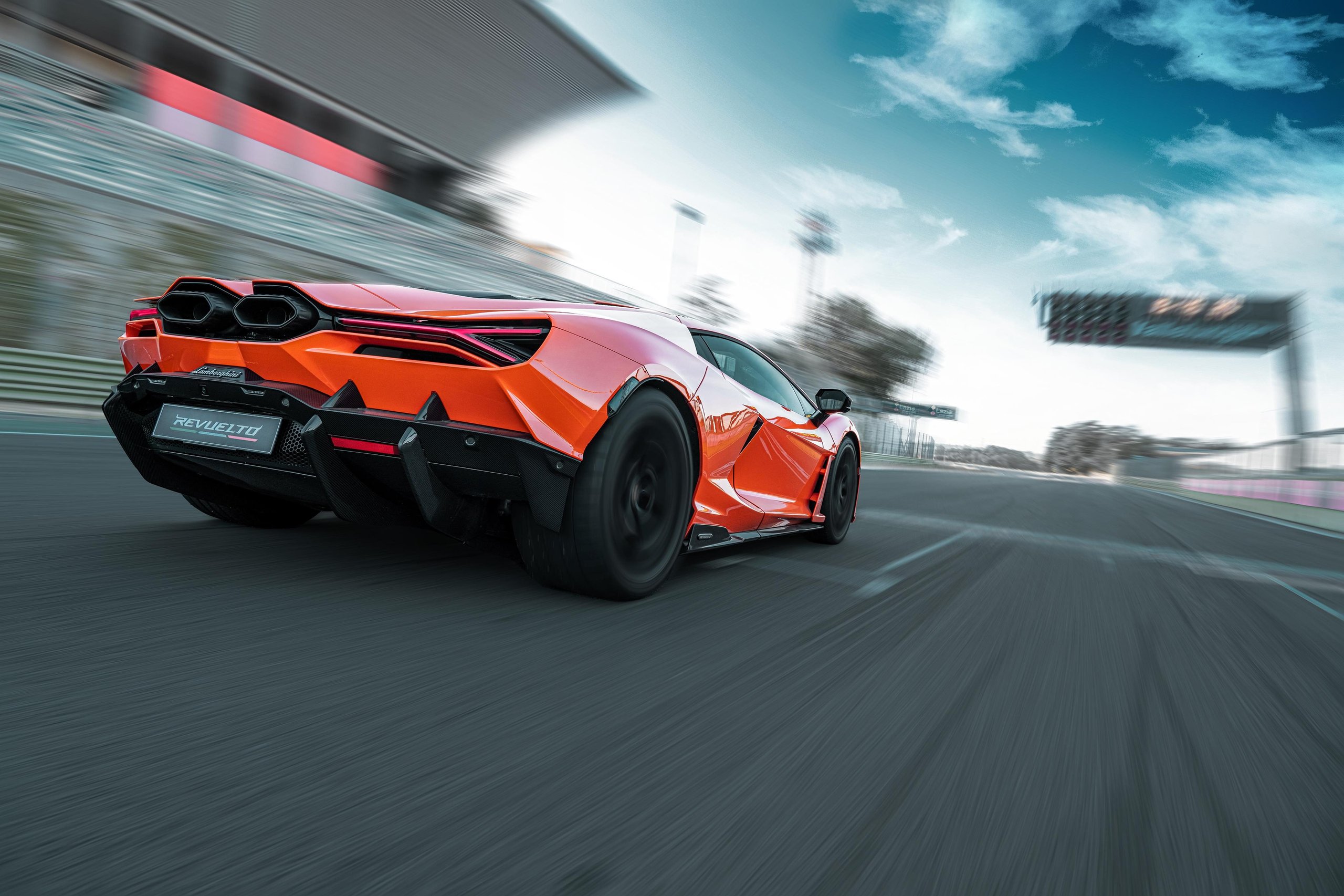 Factory Driver Caldarelli Puts The Revuelto Through Its Paces At Vallelunga, And His Verdict Tells Us More Than The Spec Sheet 7 Orange lamborghini revuelto cornering hard at vallelunga, active rear wing deployed, y-shaped taillights and rear diffuser visible