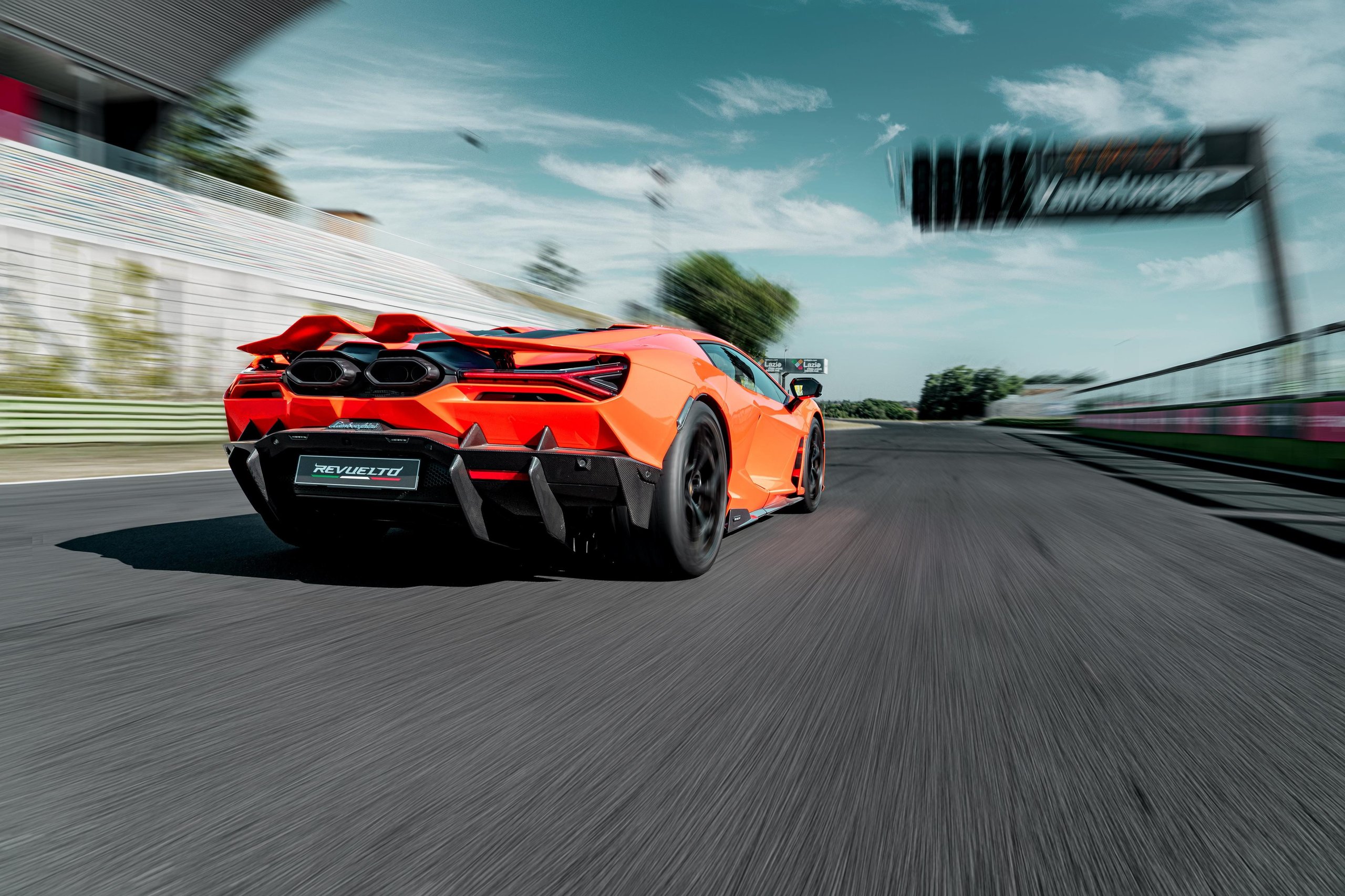 Factory Driver Caldarelli Puts The Revuelto Through Its Paces At Vallelunga, And His Verdict Tells Us More Than The Spec Sheet 9 Rear view of orange lamborghini revuelto accelerating on track, hexagonal exhaust outlets and large rear diffuser visible