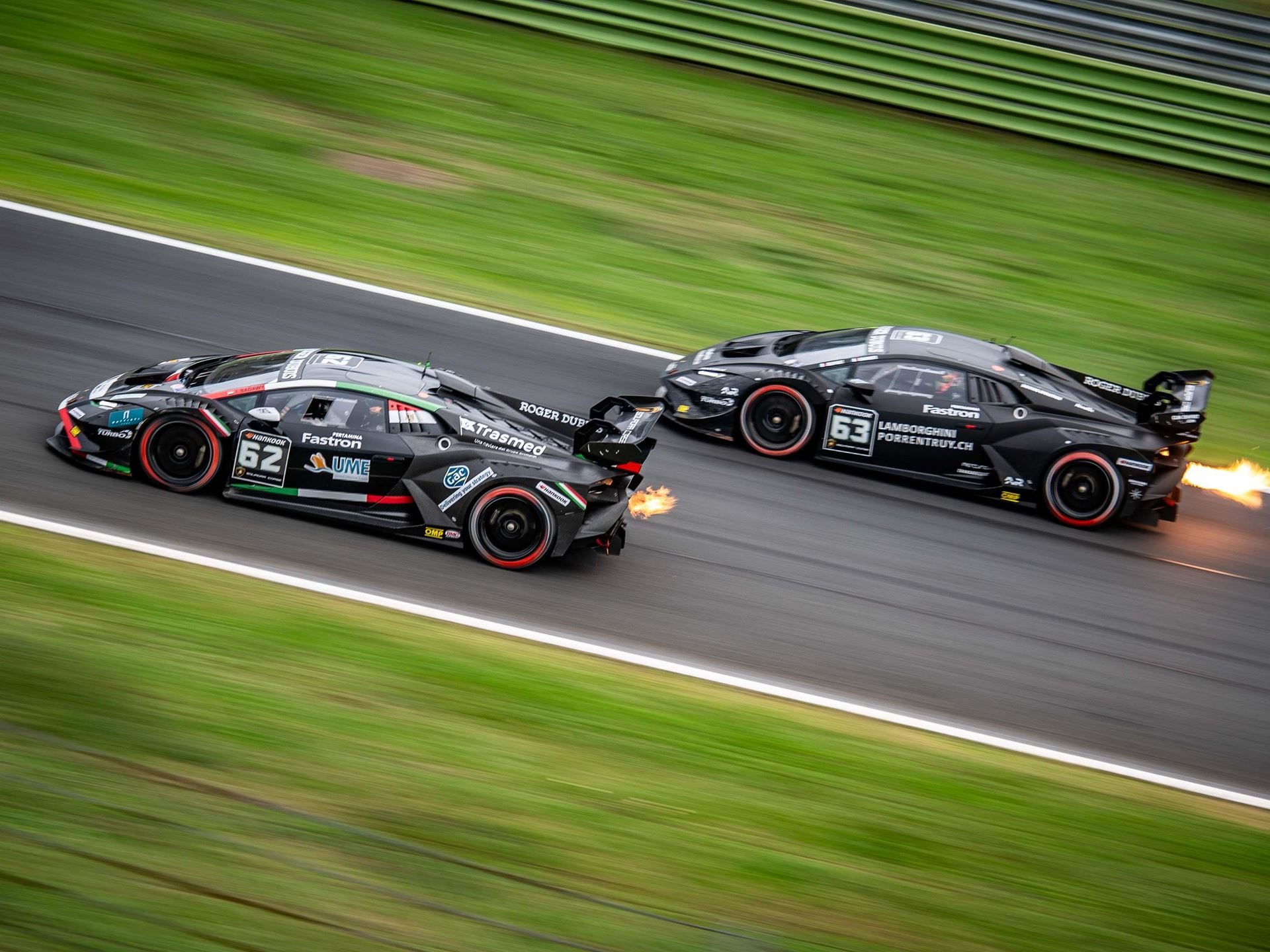 Super Trofeo Europe Joins The Fia Wec Bill At Imola, Placing Lamborghini'S Full Racing Ladder On One Stage 3 Two black lamborghini huracán super trofeo evo2 race cars at high speed on track, with exhaust flames visible from the trailing car