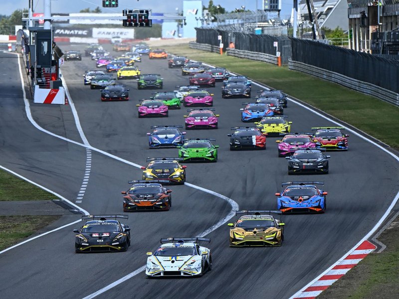 Full grid of Lamborghini Huracán Super Trofeo EVO2 race cars lined up at the start of a race, displaying a variety of vibrant racing liveries