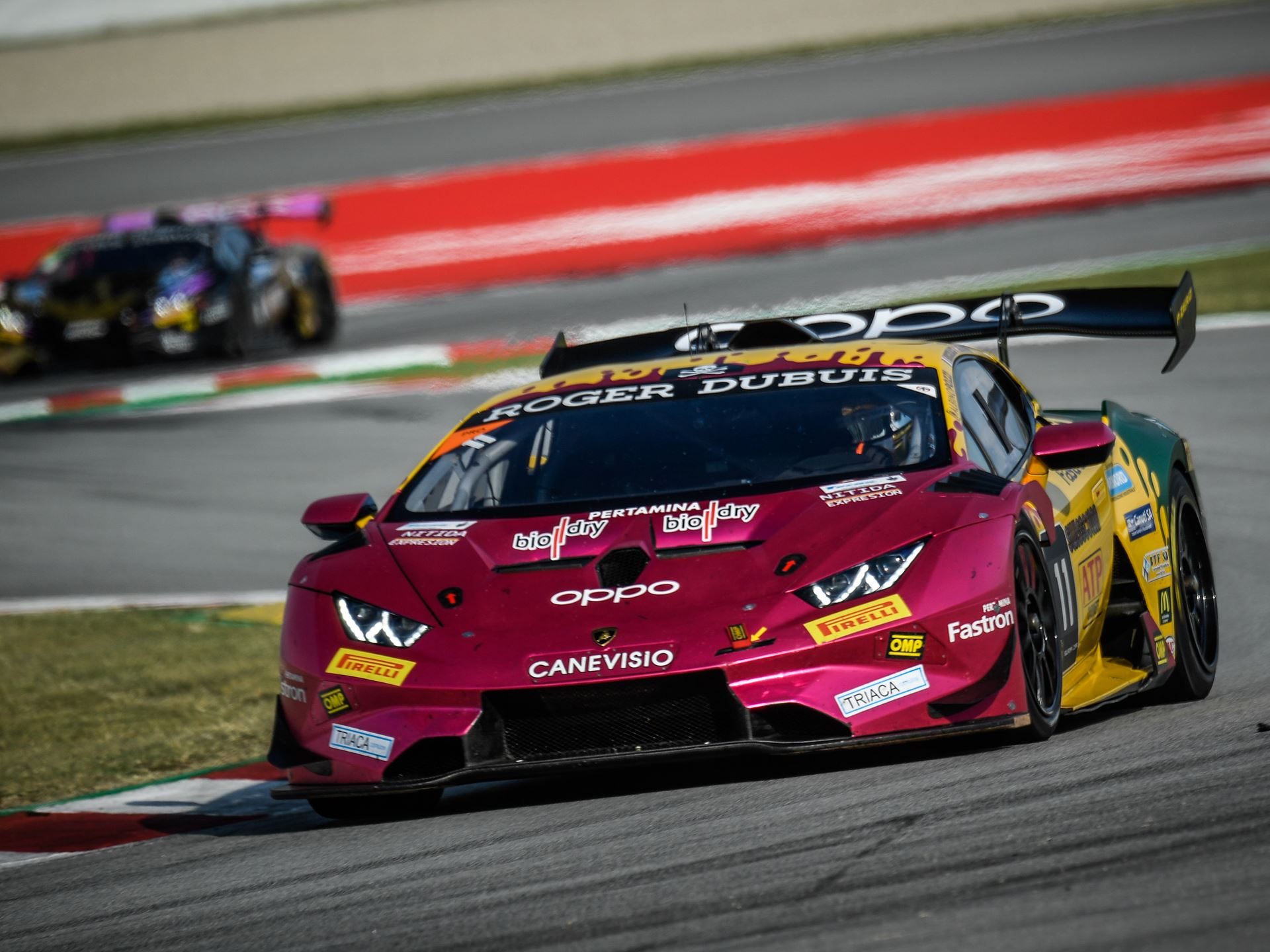 Oregon Team's number 11 Lamborghini Huracán Super Trofeo EVO2 racing at Barcelona with prominent rear wing and LED headlights visible