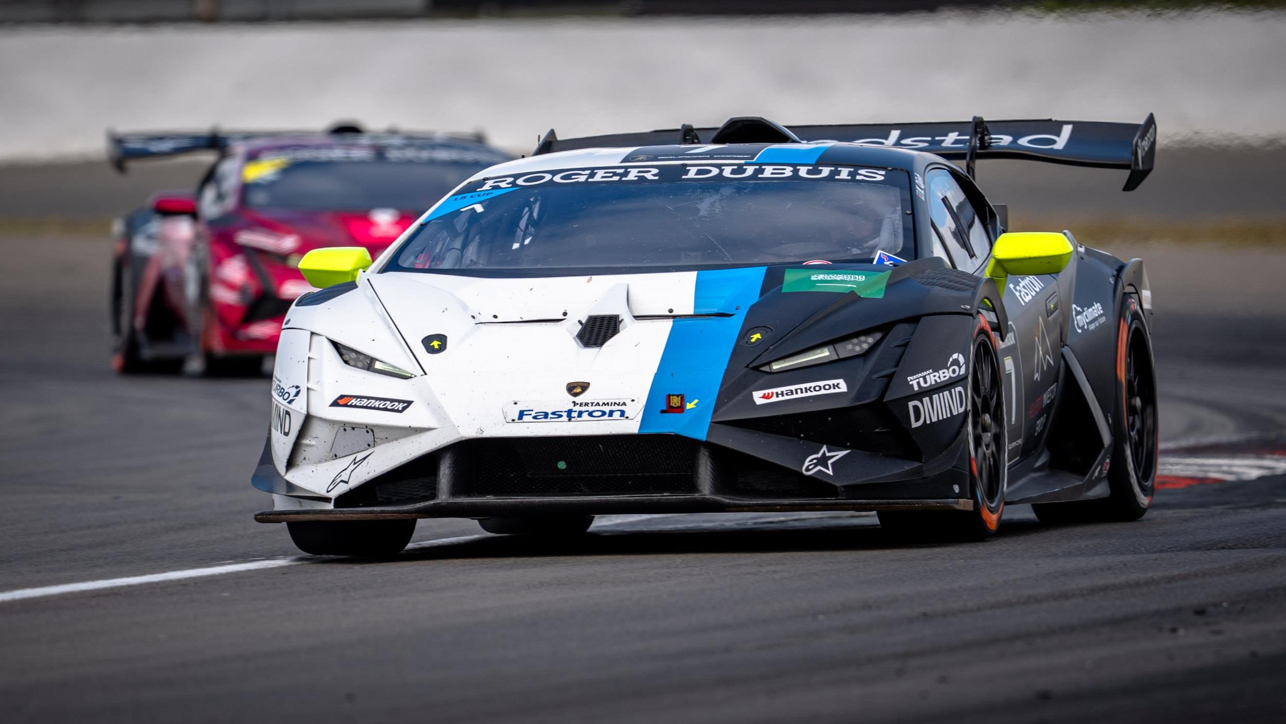 Close-up of a white and black lamborghini huracán super trofeo evo2 with yellow accents showing aggressive front aerodynamics and racing-specific design elements