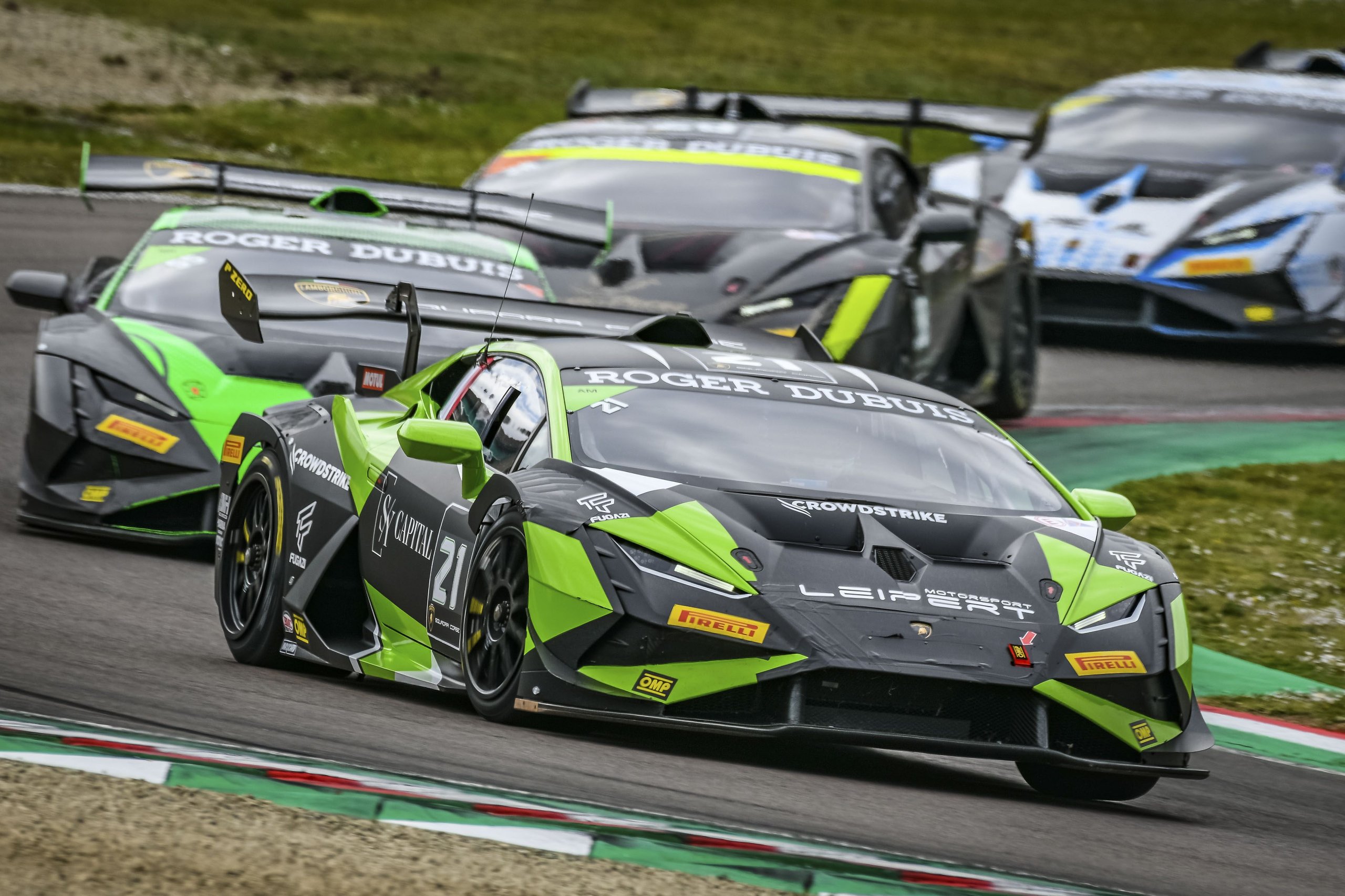 Pedrosa Returns, A Perfect Streak Faces Misano'S Evening Grid, And Four Classes Fight For Points 5 A lime green and black lamborghini huracán super trofeo evo2 number 21 leading a pack of race cars through a corner