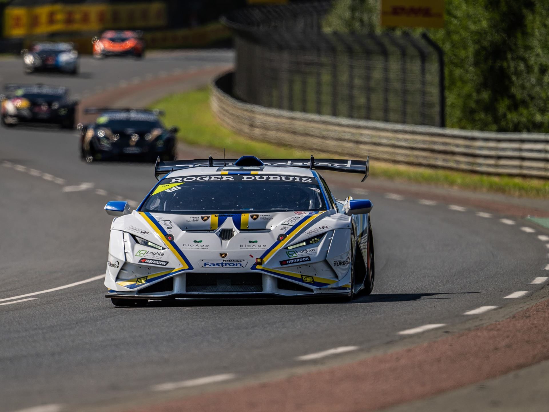Super Trofeo Europe Hits The Nürburgring With A 1.5-Point Pro Title Fight 7 A white and blue lamborghini huracán super trofeo evo2 from the front navigating a wide curve on a sunny race track