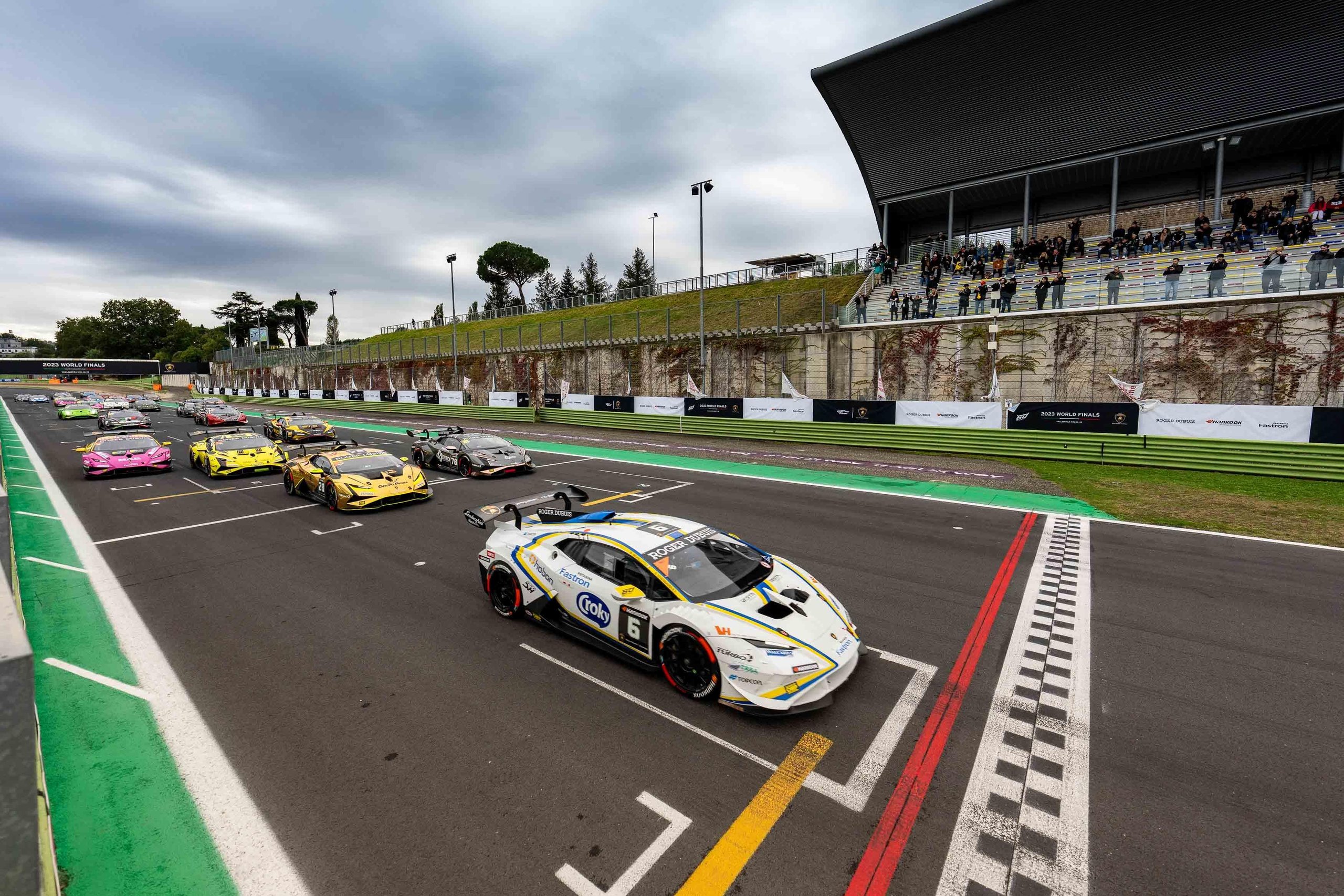 Fifty Cars, Four Open Championships, And One Week Left: Super Trofeo Europe'S Vallelunga Showdown 3 A packed starting grid of lamborghini huracán super trofeo evo2 race cars at vallelunga with spectators in the grandstand