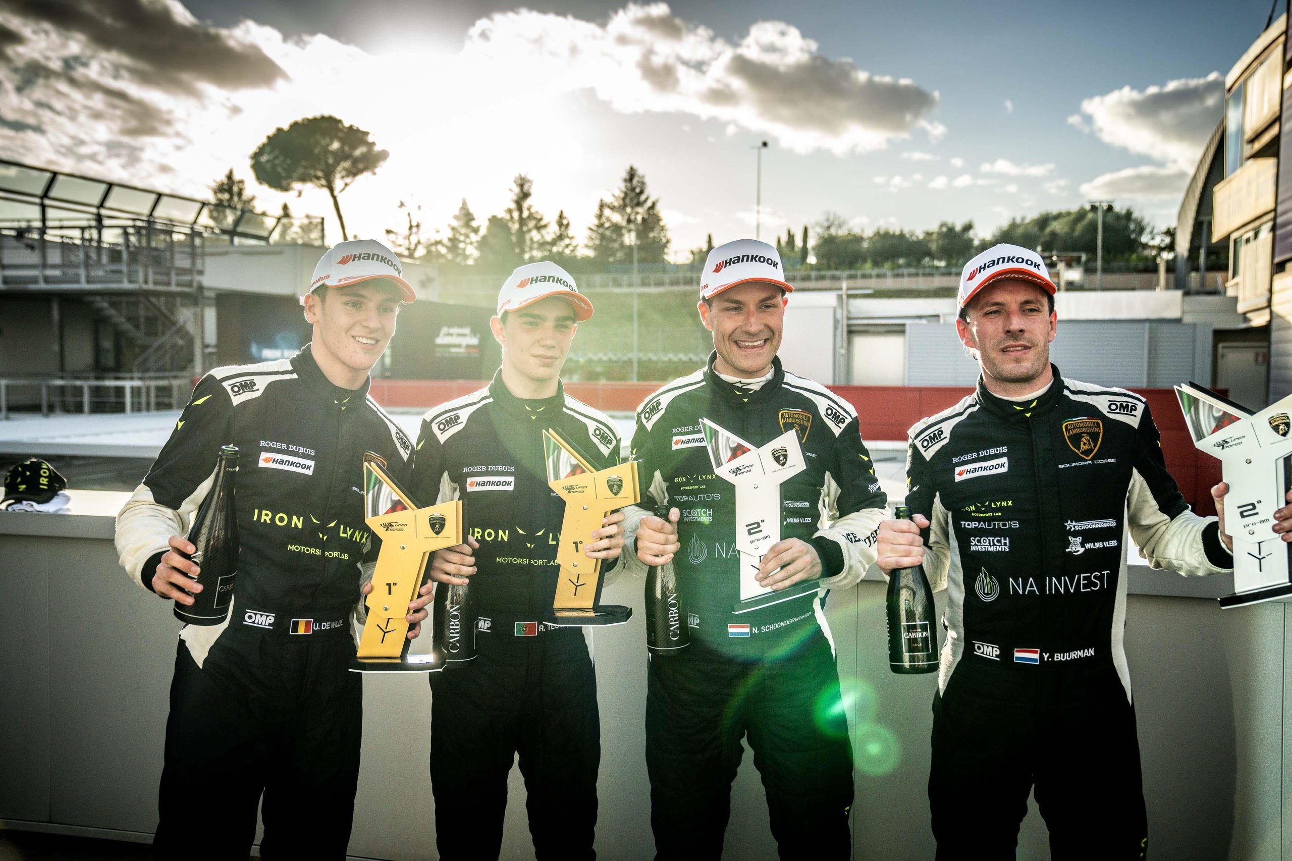 Fifty Cars, Four Open Championships, And One Week Left: Super Trofeo Europe'S Vallelunga Showdown 7 Four race car drivers on the podium at vallelunga holding trophies and champagne bottles