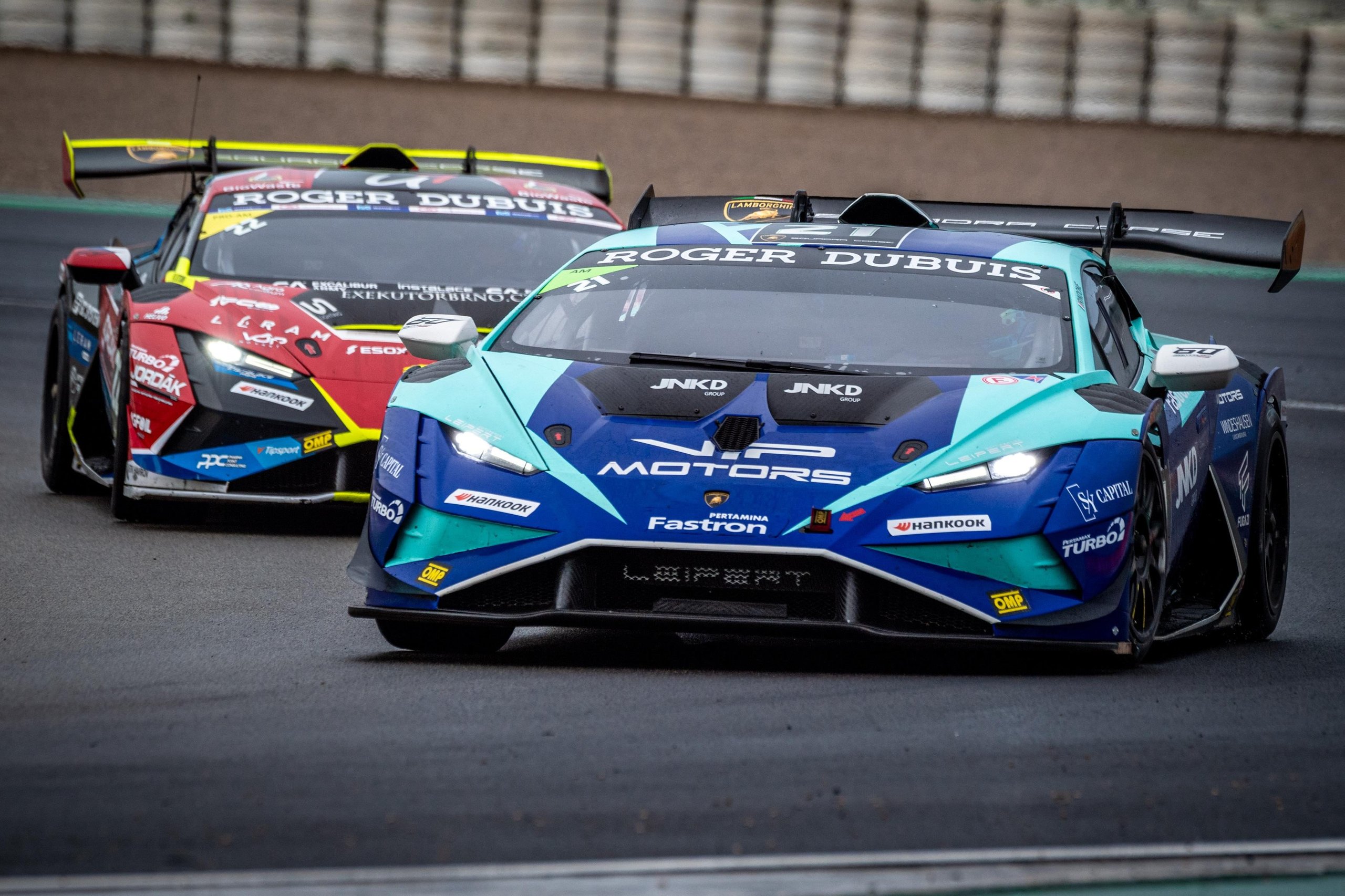 52 Huracán Evo2S At Vallelunga: Why The Super Trofeo'S Record Grid Matters Beyond The Championship Fight 7 Two lamborghini huracán super trofeo evo2 race cars in close pursuit, a blue and teal car leading a red and black car