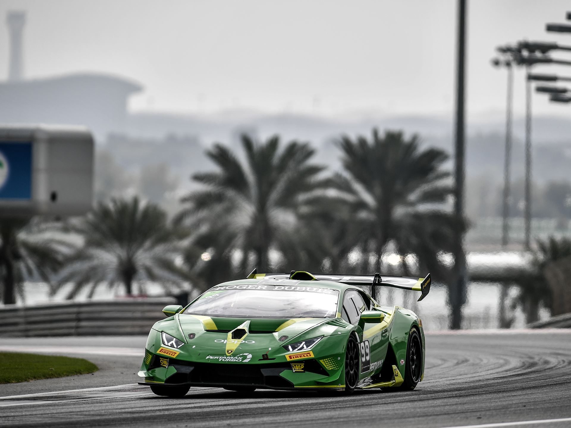 Lamborghini Super Trofeo Middle East Comeback Signals Squadra Corse'S Regional Ambitions For 2022 3 Green lamborghini huracán super trofeo evo race car number 99 mid-corner on a racetrack with palm trees in the background