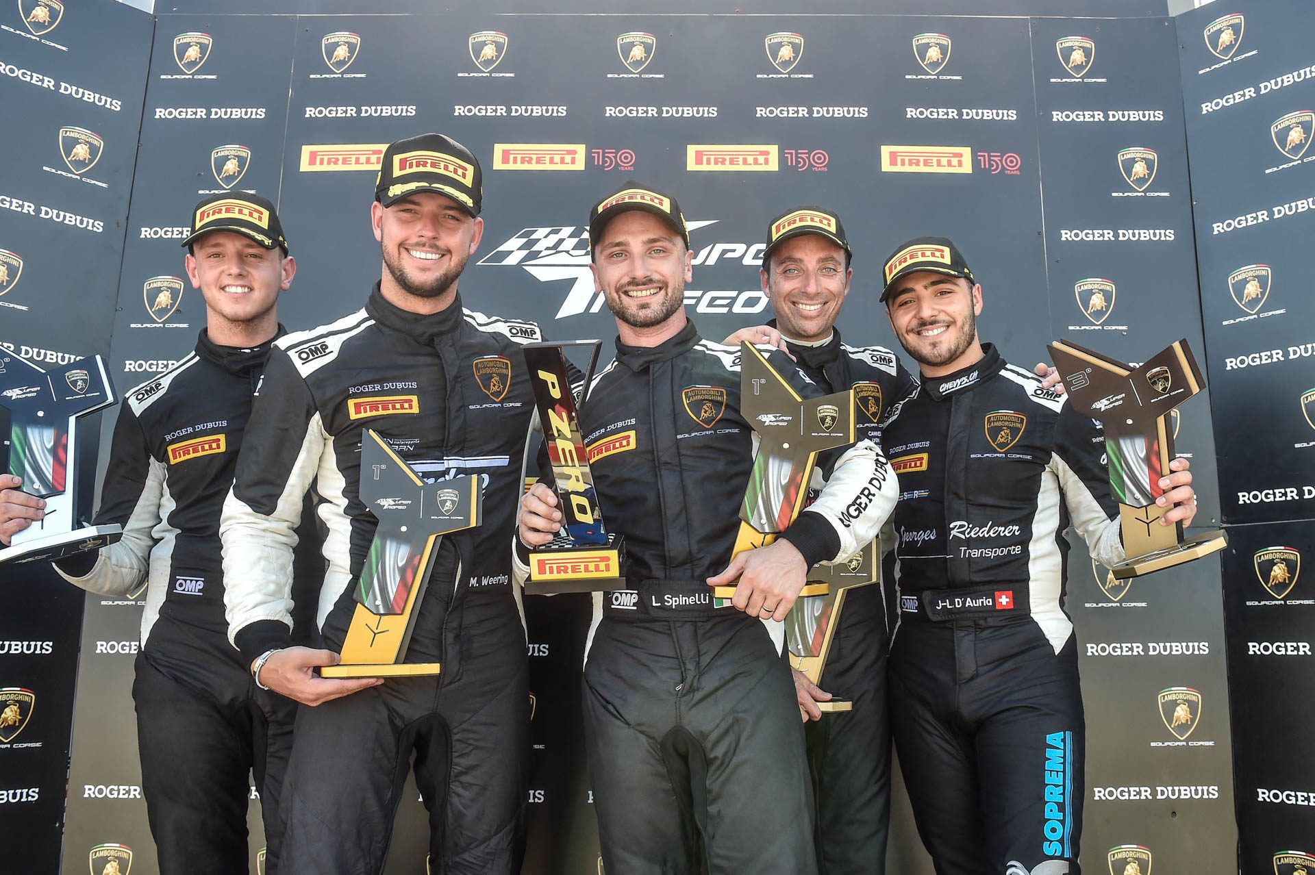 Six From Six: How Weering And Spinelli'S Record Run Reveals What Lamborghini'S Customer Racing Actually Builds 7 Race drivers on the podium holding trophies with roger dubuis and pirelli branding at the lamborghini super trofeo