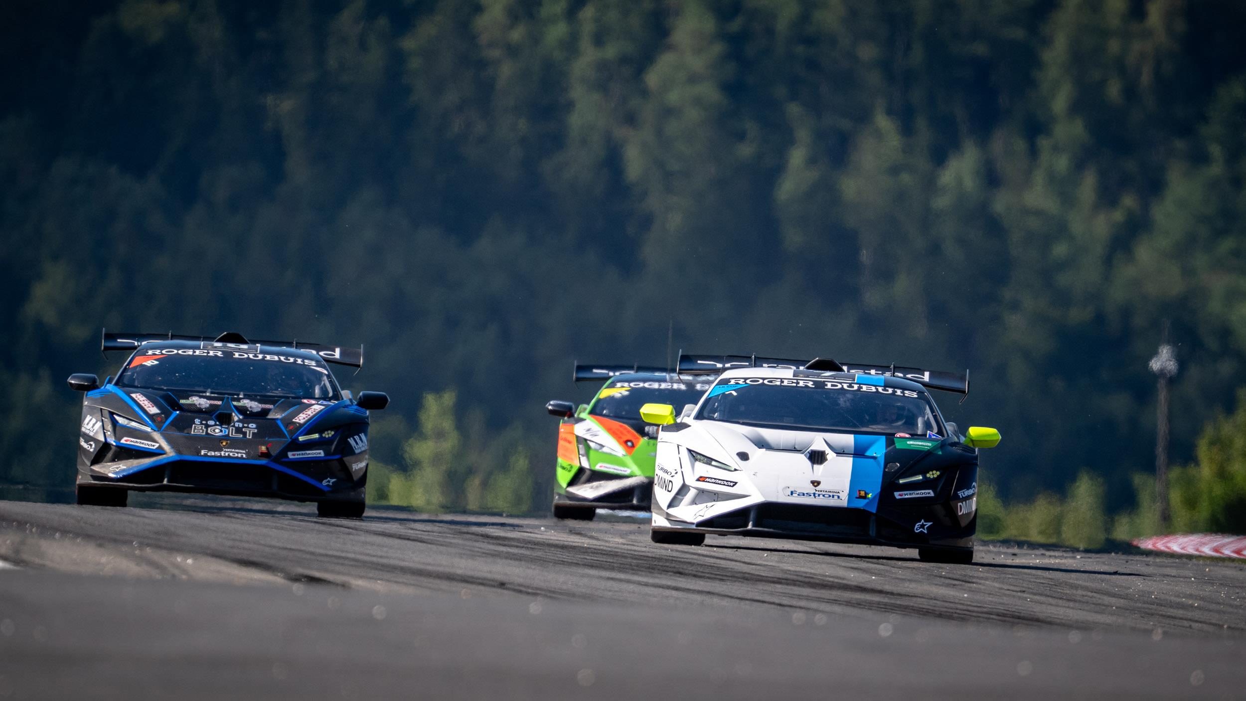 Three lamborghini huracán super trofeo evo2 race cars battling closely on the nürburgring circuit