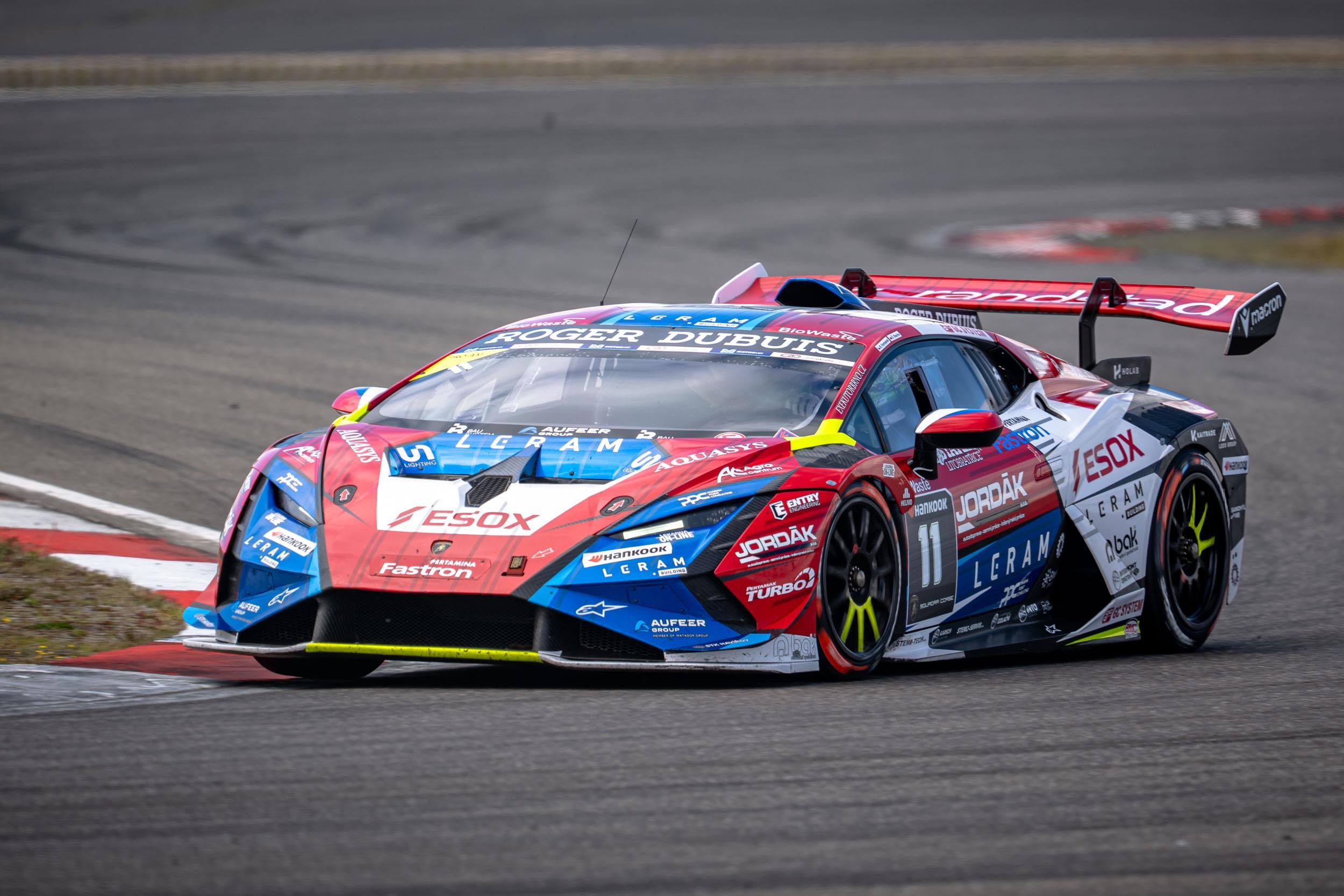 A red, white, and blue lamborghini huracán super trofeo evo2 cornering at the nürburgring