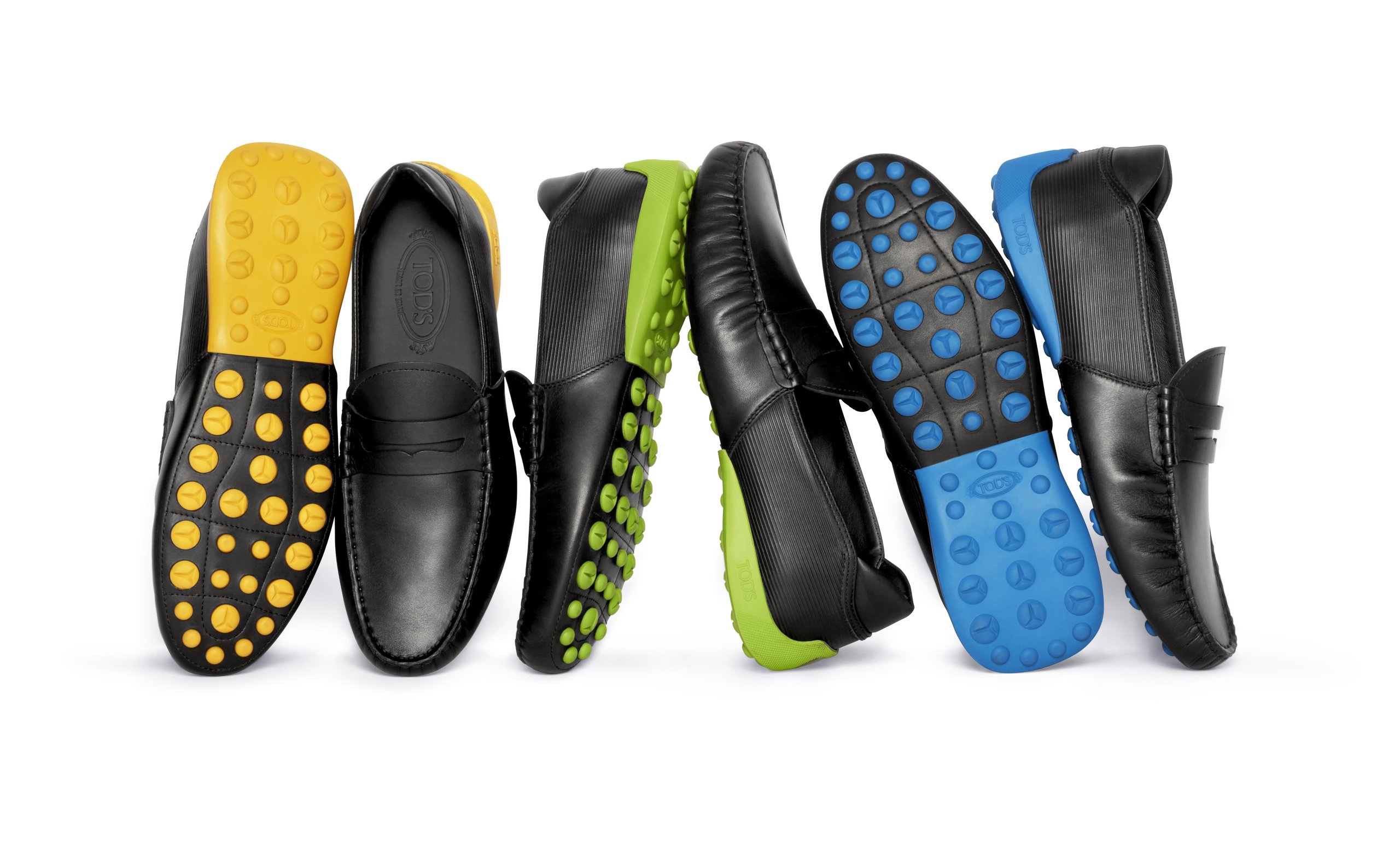 Tod'S X Automobili Lamborghini: What A Driving Shoe Tells You About Where The Brand Is Headed 5 Three pairs of black tod's for automobili lamborghini driving shoes with yellow, green, and blue soles arranged in a row against a white background