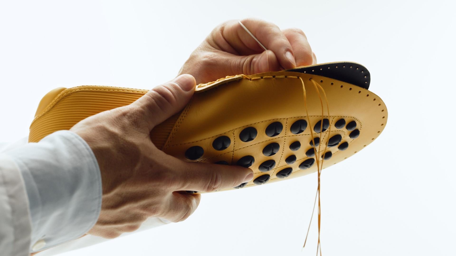 Tod'S X Automobili Lamborghini: What A Driving Shoe Tells You About Where The Brand Is Headed 7 Hands meticulously stitching a yellow leather tod's for automobili lamborghini driving shoe against a white background