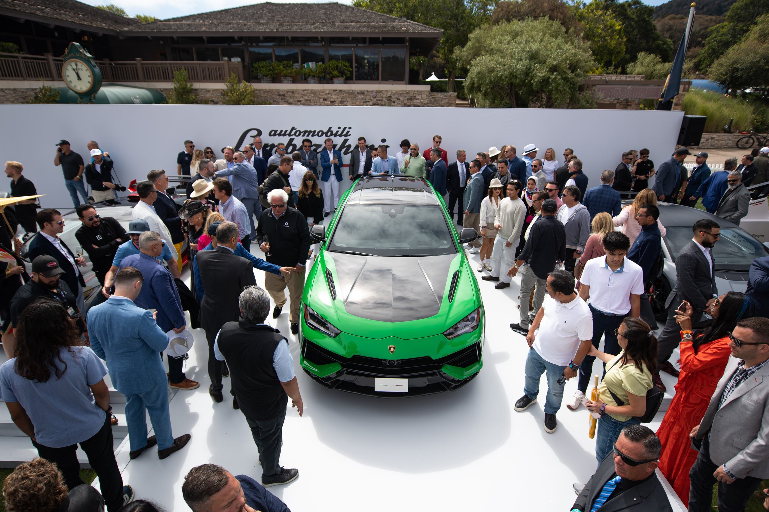 How Lamborghini Turned The Quail Into A Heritage Argument For The Urus Performante 5 Large crowd gathered around the green lamborghini urus performante at the quail, with the automobili lamborghini logo on the white backdrop