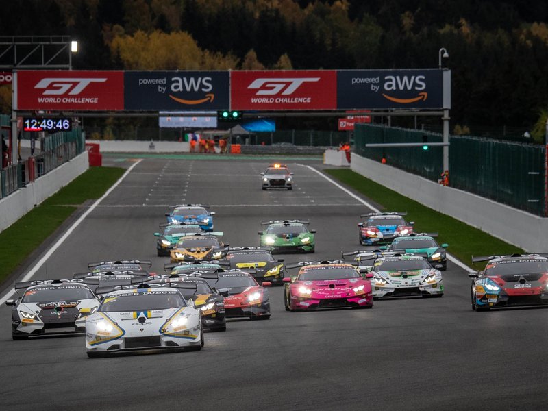 A pack of Lamborghini Huracán Super Trofeo EVO race cars battling for position on track under overcast skies at Spa-Francorchamps