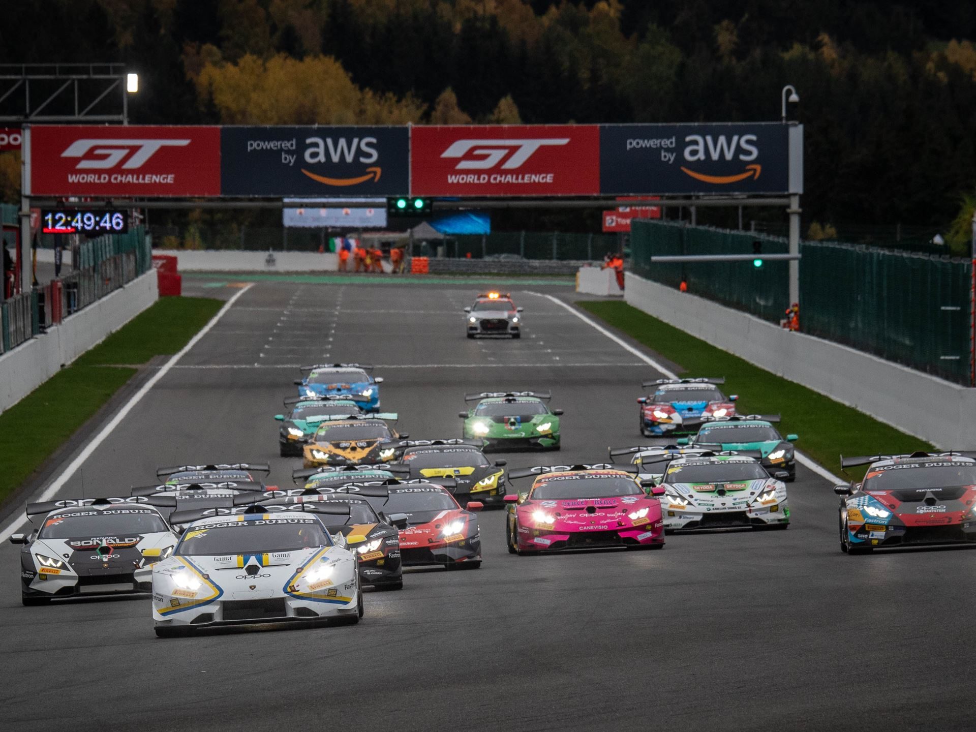 A pack of Lamborghini Huracán Super Trofeo EVO race cars battling for position on track under overcast skies at Spa-Francorchamps