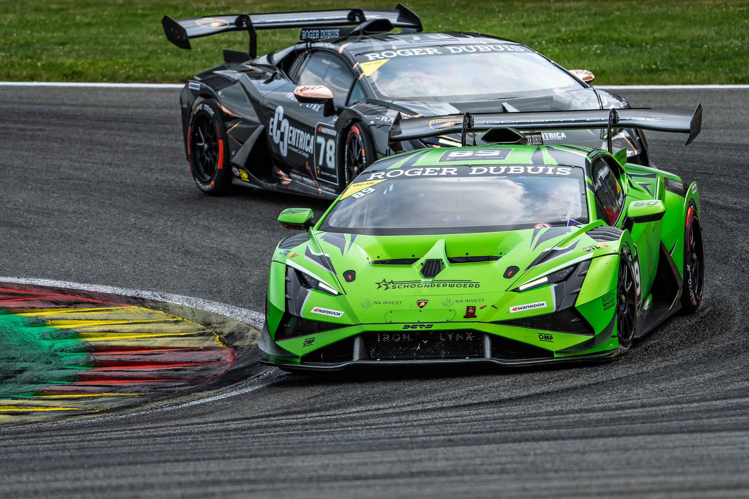 A bright green lamborghini huracán super trofeo evo2 leads a competitor through a corner at spa