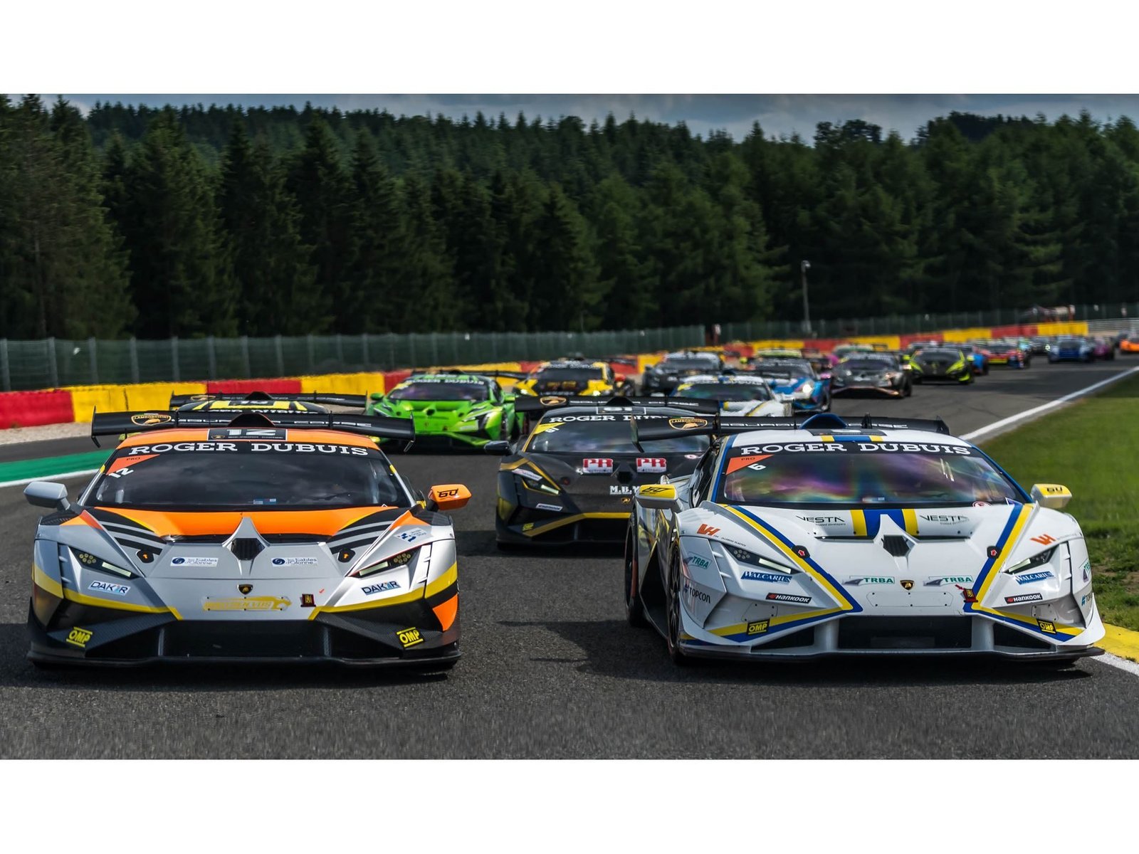 Two Lamborghini Huracán Super Trofeo EVO2 race cars leading a pack of competitors at Spa-Francorchamps